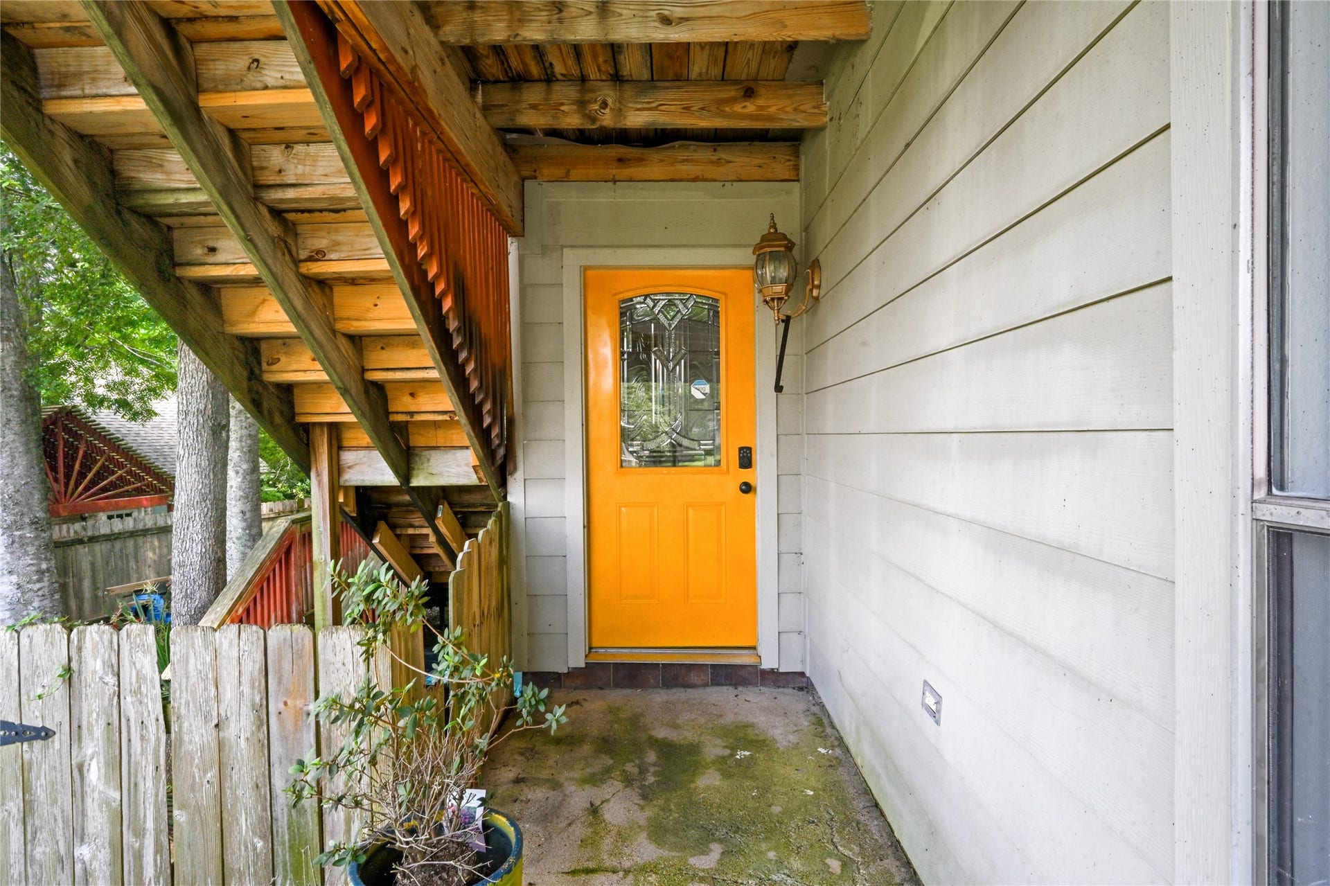 107 Harbour Town Lane, Conroe, TX 77356 Covered entryway area featuring a vibrant, welcoming orange front door that adds a pop of modern curb appeal.