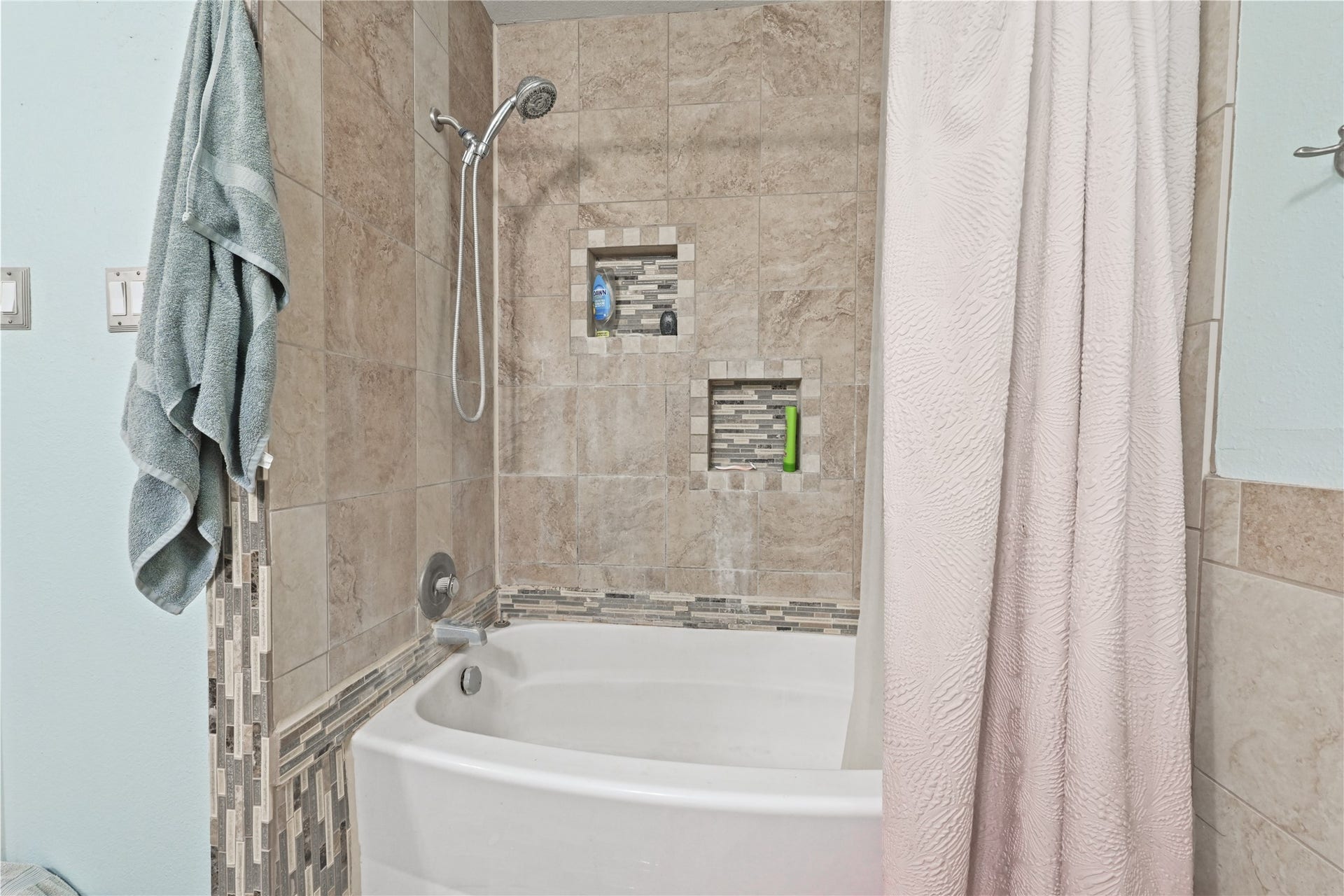 107 Harbour Town Lane, Conroe, TX 77356 En-suite bath area featuring a soaking tub and tiled surround with integrated shelving cutouts.