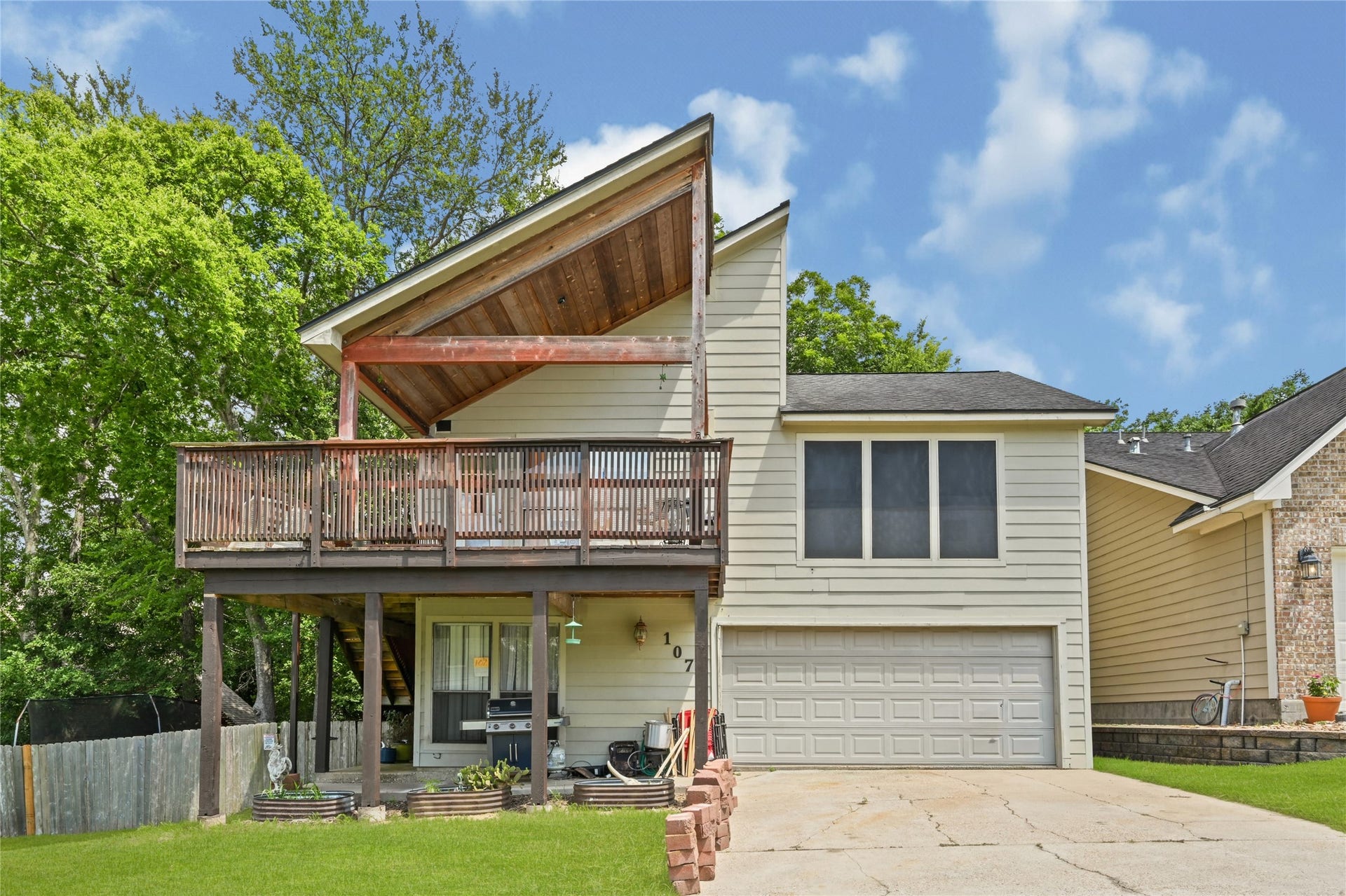 107 Harbour Town Lane, Conroe, TX 77356 Dynamic angle of the front exterior emphasizing the dramatic architectural lines and elevated outdoor balcony space.