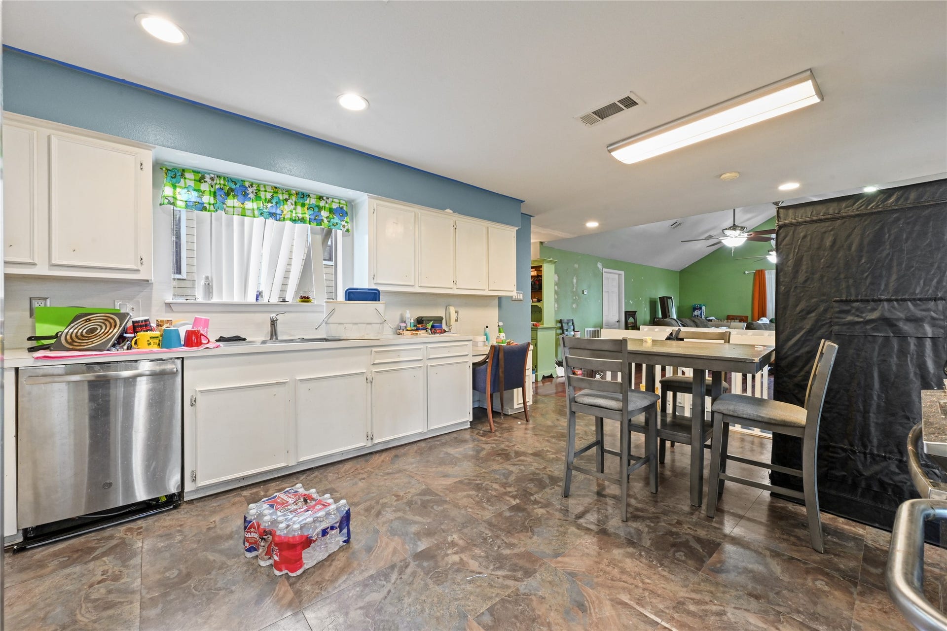 107 Harbour Town Lane, Conroe, TX 77356 Wide-angle view of the kitchen showcasing the durable flooring, ample cabinet storage, and bright recessed lighting.