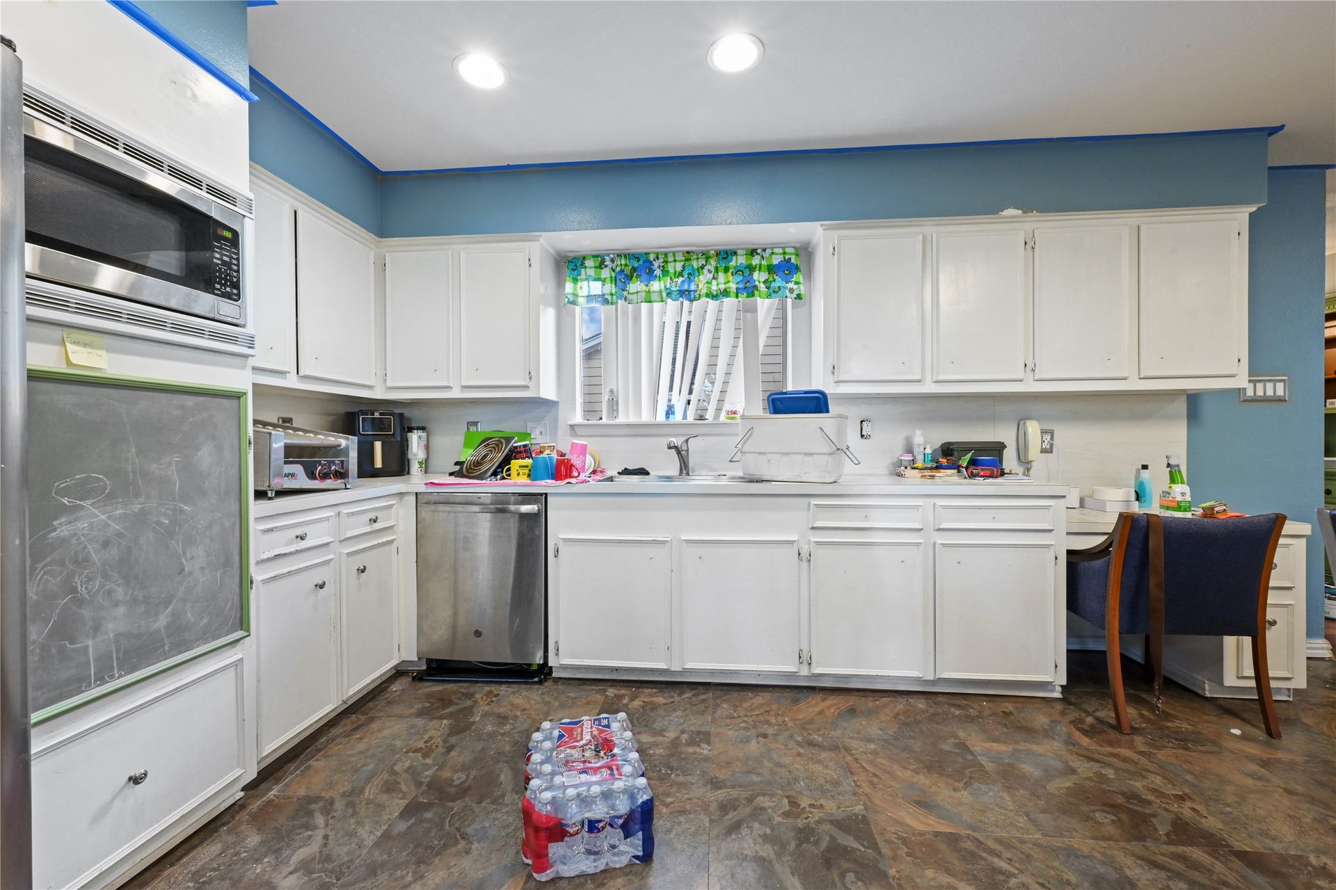107 Harbour Town Lane, Conroe, TX 77356 Bright, functional kitchen boasting white cabinetry, modern countertops, a window over the sink, and built-in stainless steel appliances.