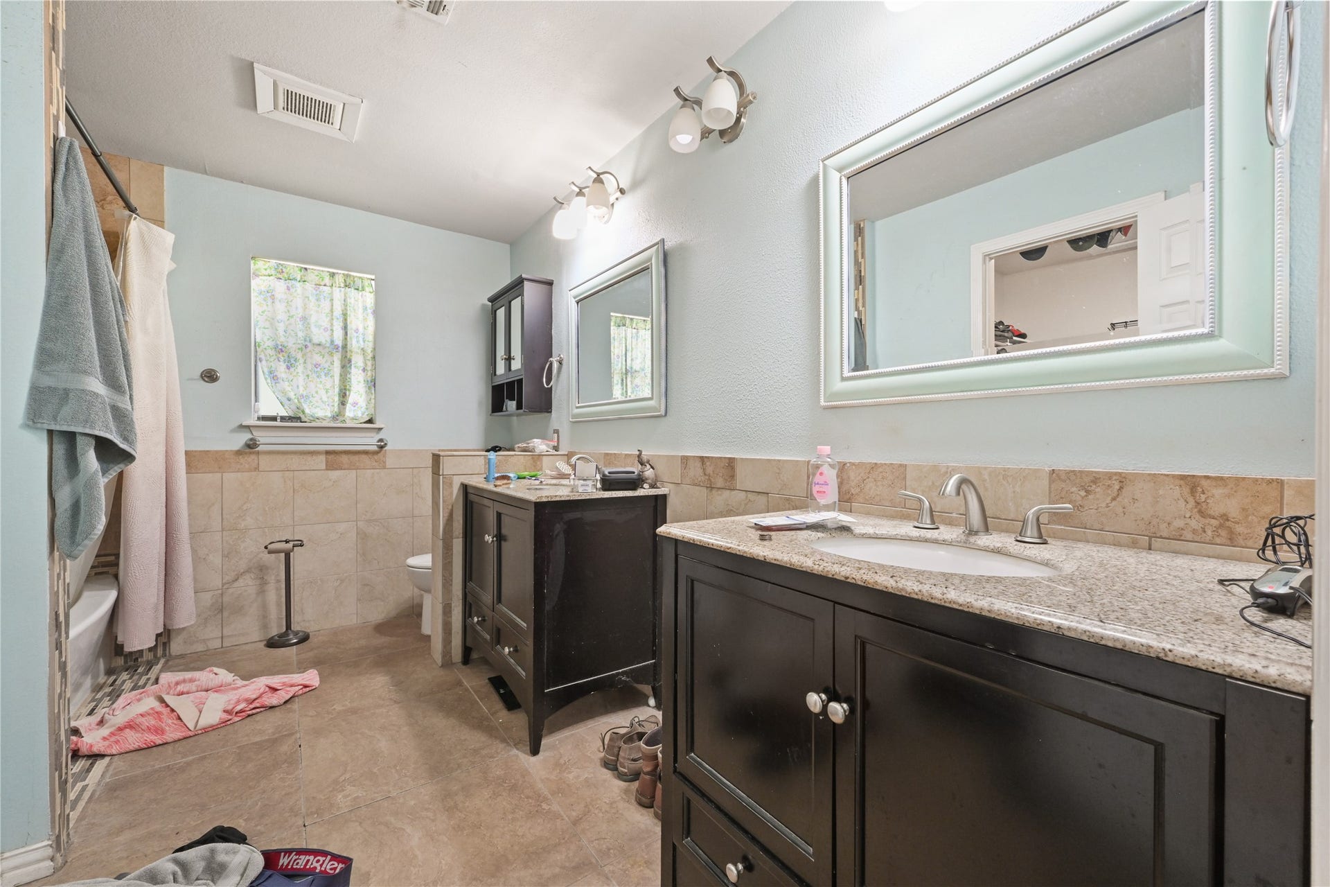 107 Harbour Town Lane, Conroe, TX 77356 Large en-suite bathroom featuring dual independent vanities with dark wood cabinetry and modern framed mirrors.