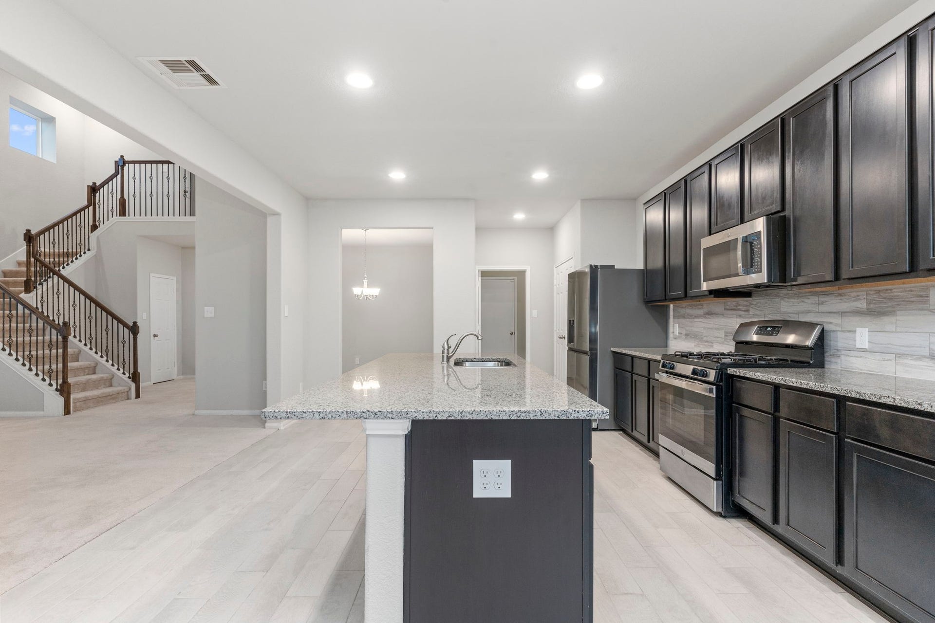 5406 Rustic Ruby Dr, Fulshear, TX 77423 Rich dark wood cabinets adorn the Kitchen for ample storage