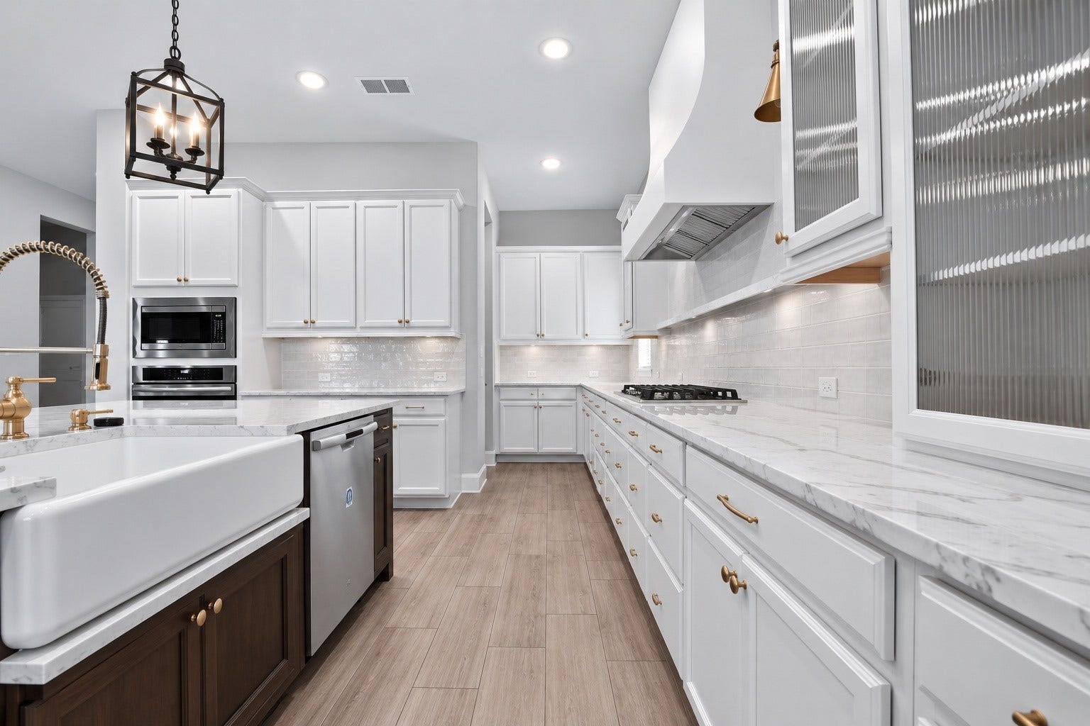 1515 Shining Willow Court, Richmond, TX 77406 Spacious gourmet kitchen featuring white cabinetry, quartz countertops, a large contrasting island, farmhouse sink, stainless steel appliances, and beautiful gold accents throughout.