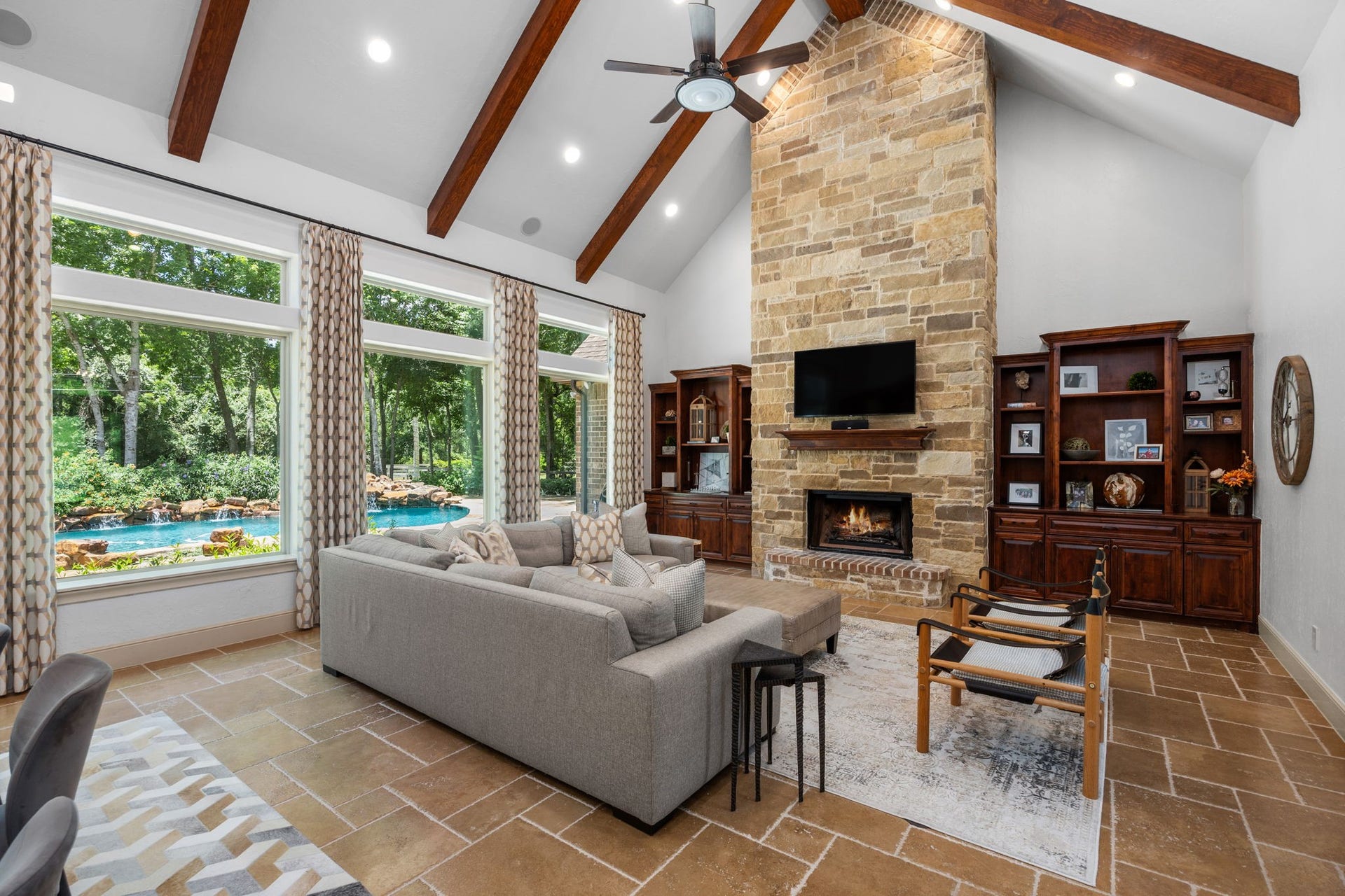 2734 Forest View, Richmond, TX 77406 Living area features high wood beamed ceiling, rock and brick fireplace, lots of built in cabinets and shelves and an awesome view of the pool and grounds.