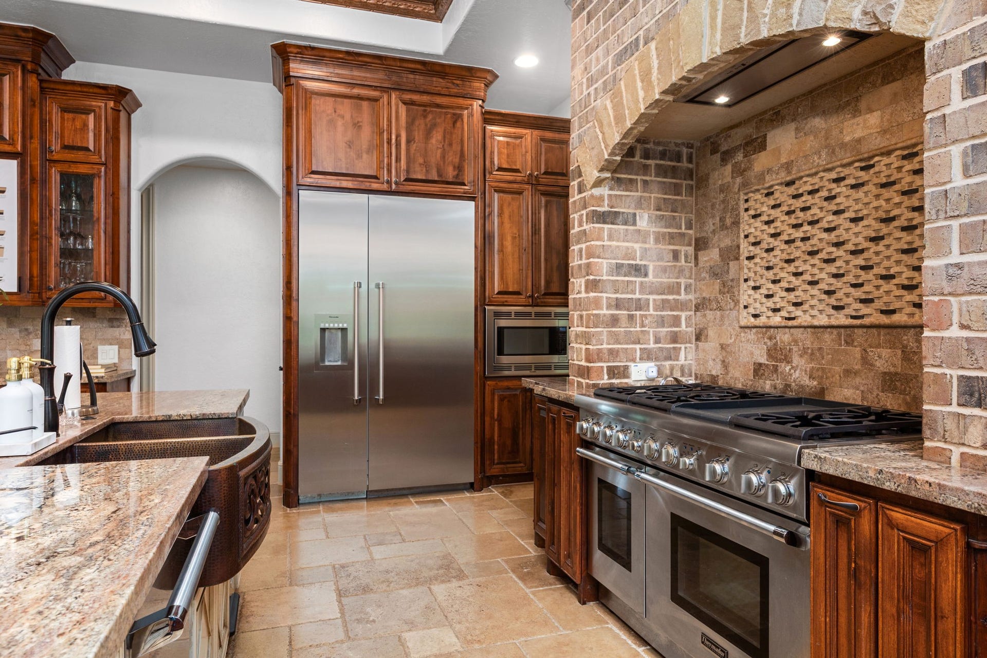 2734 Forest View, Richmond, TX 77406 Thermador fridge/freezer and 6 burner range with dedicated grill and copper Farmer's sink elevate the gourmet kitchen.
