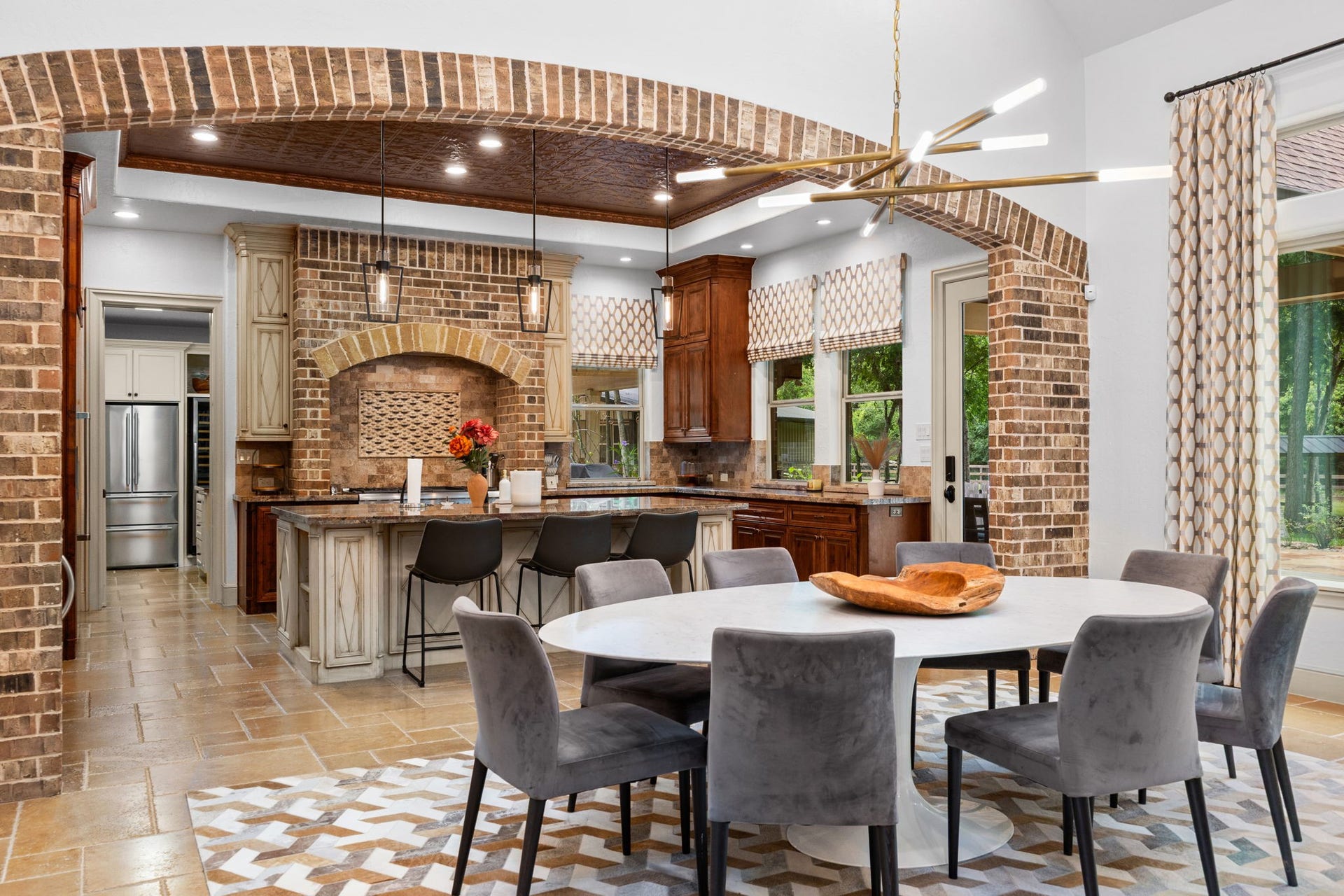 2734 Forest View, Richmond, TX 77406 Kitchen has all high end appliances. Beautiful stone/brick and tile accents. Seating for three at the island. Door to the right leads to outdoor covered patio. Left doorway flows to the Butler's pantry.