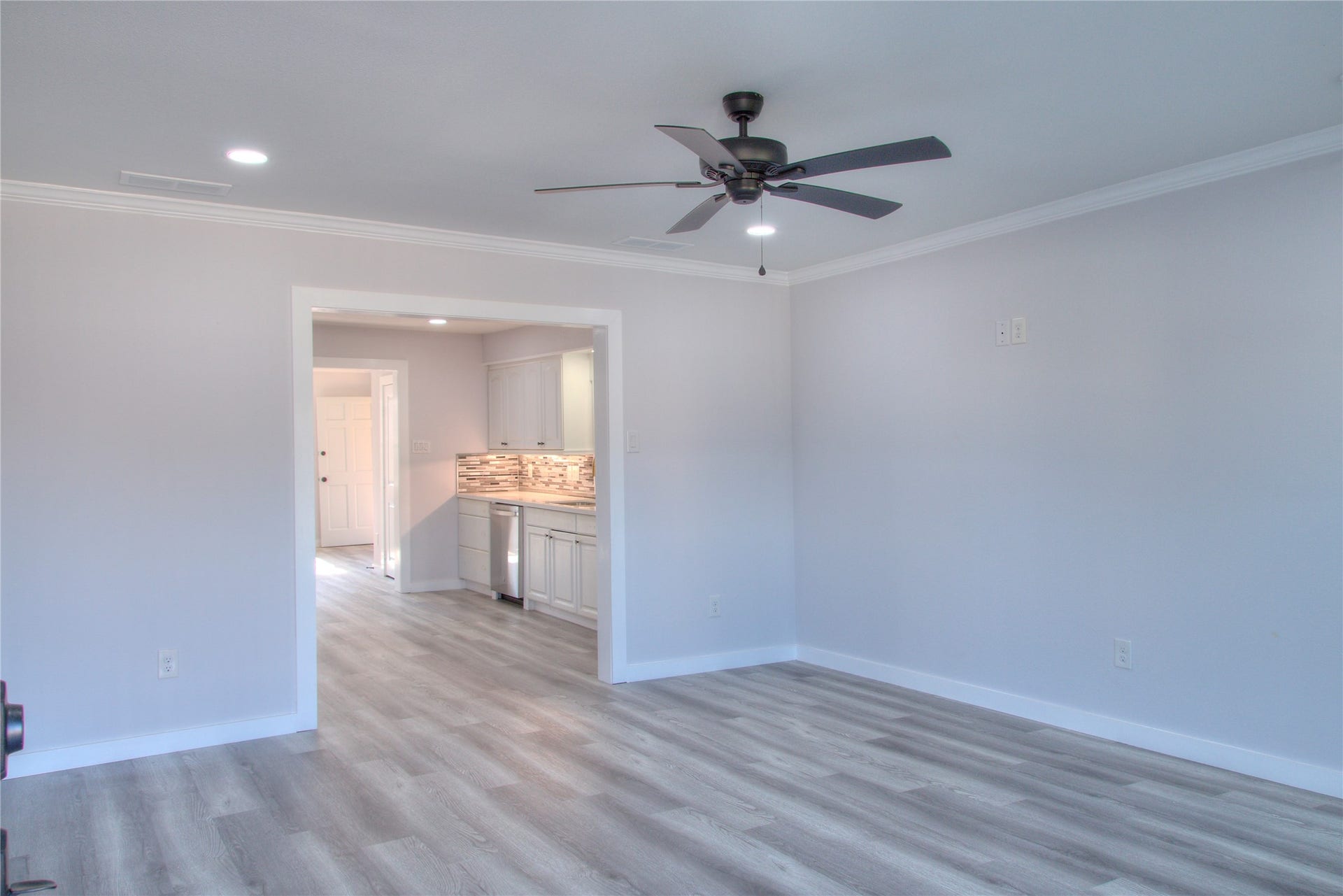 415 Perkins Avenue, League City, TX 77573 Discover a spacious family room featuring modern updates, including new canister lights, ceiling fan, flooring, baseboards, crown molding, front door, and windows.