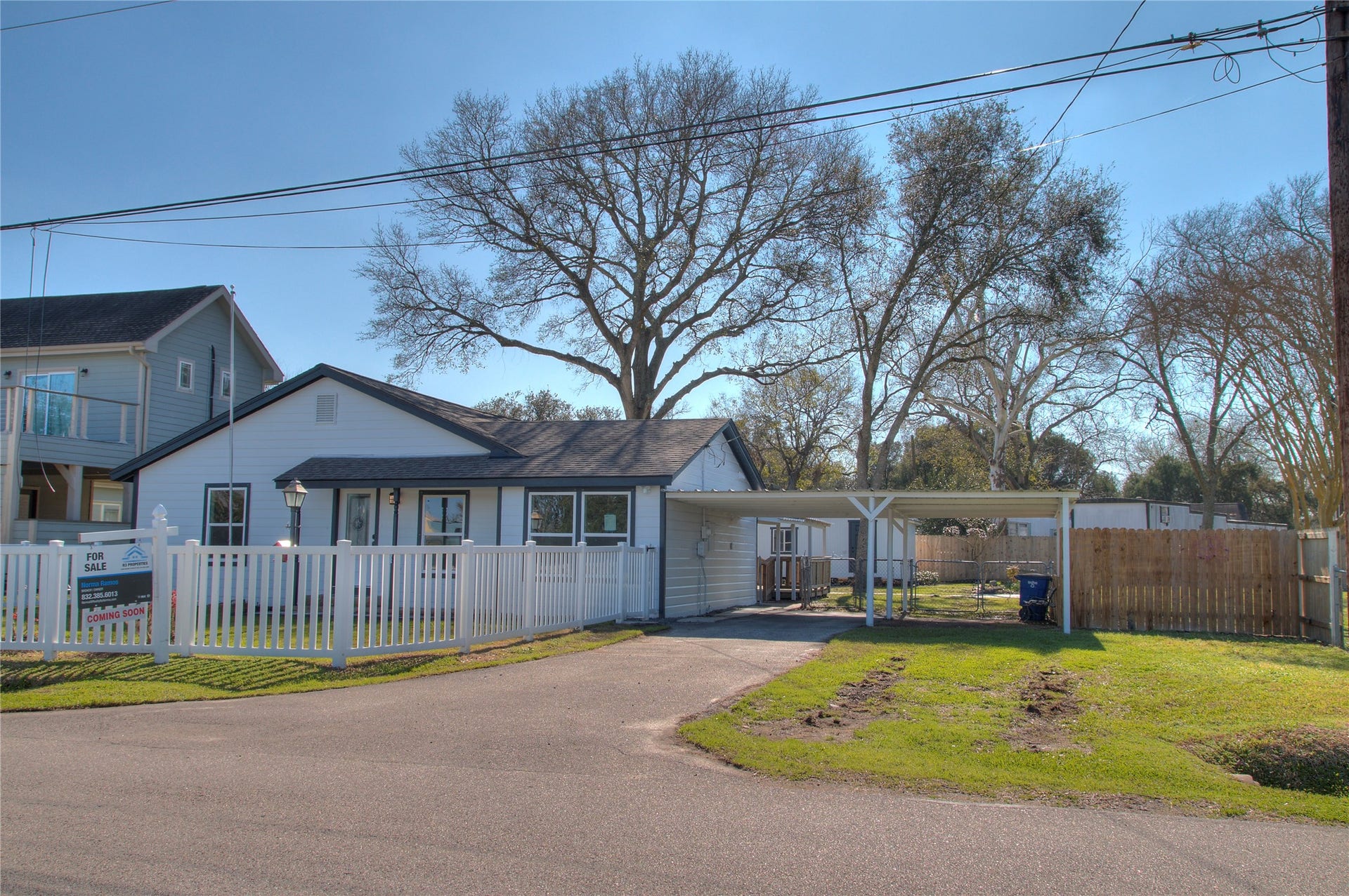 415 Perkins Avenue, League City, TX 77573 Front view of a charming single-story home featuring an attached two-car carport and additional RV parking space.