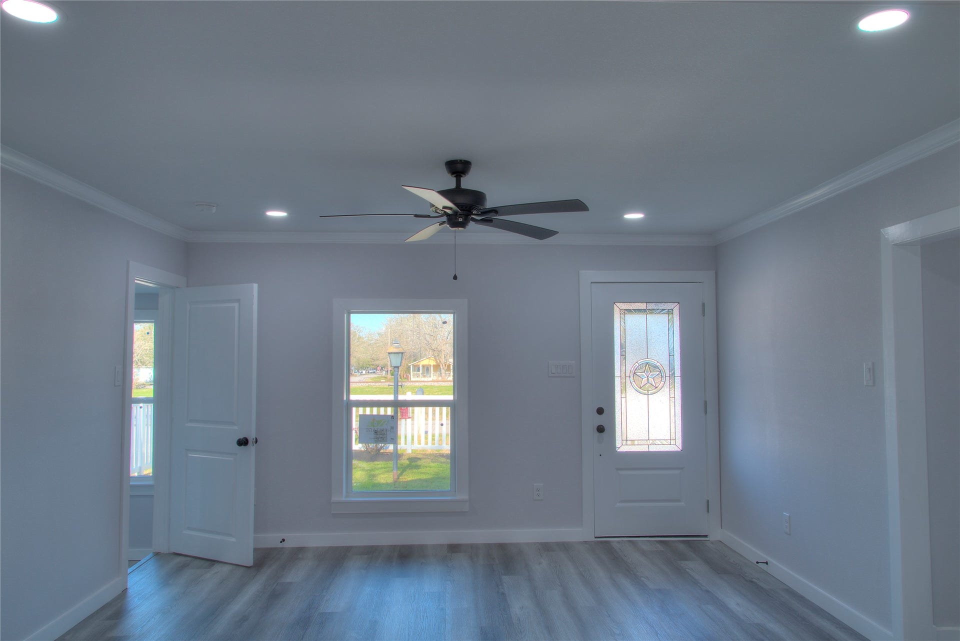 415 Perkins Avenue, League City, TX 77573 Inviting family room with a ceiling fan, modern canister lighting, and a stunning glass front door.