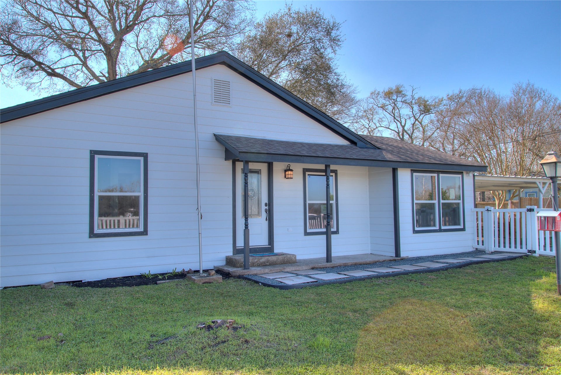 415 Perkins Avenue, League City, TX 77573 Charming front view with a welcoming covered porch and elegant stepping stones.