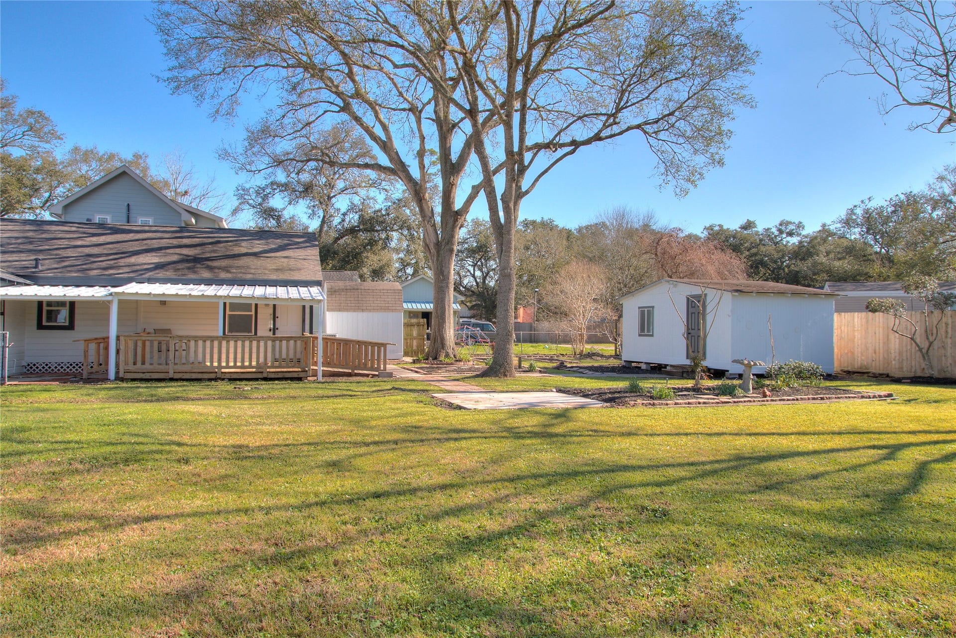 415 Perkins Avenue, League City, TX 77573 This charming property features a covered patio with decking and convenient ramp access, a storage shed, and a versatile shed with electricityperfect for a workshop or potential guest house conversion.