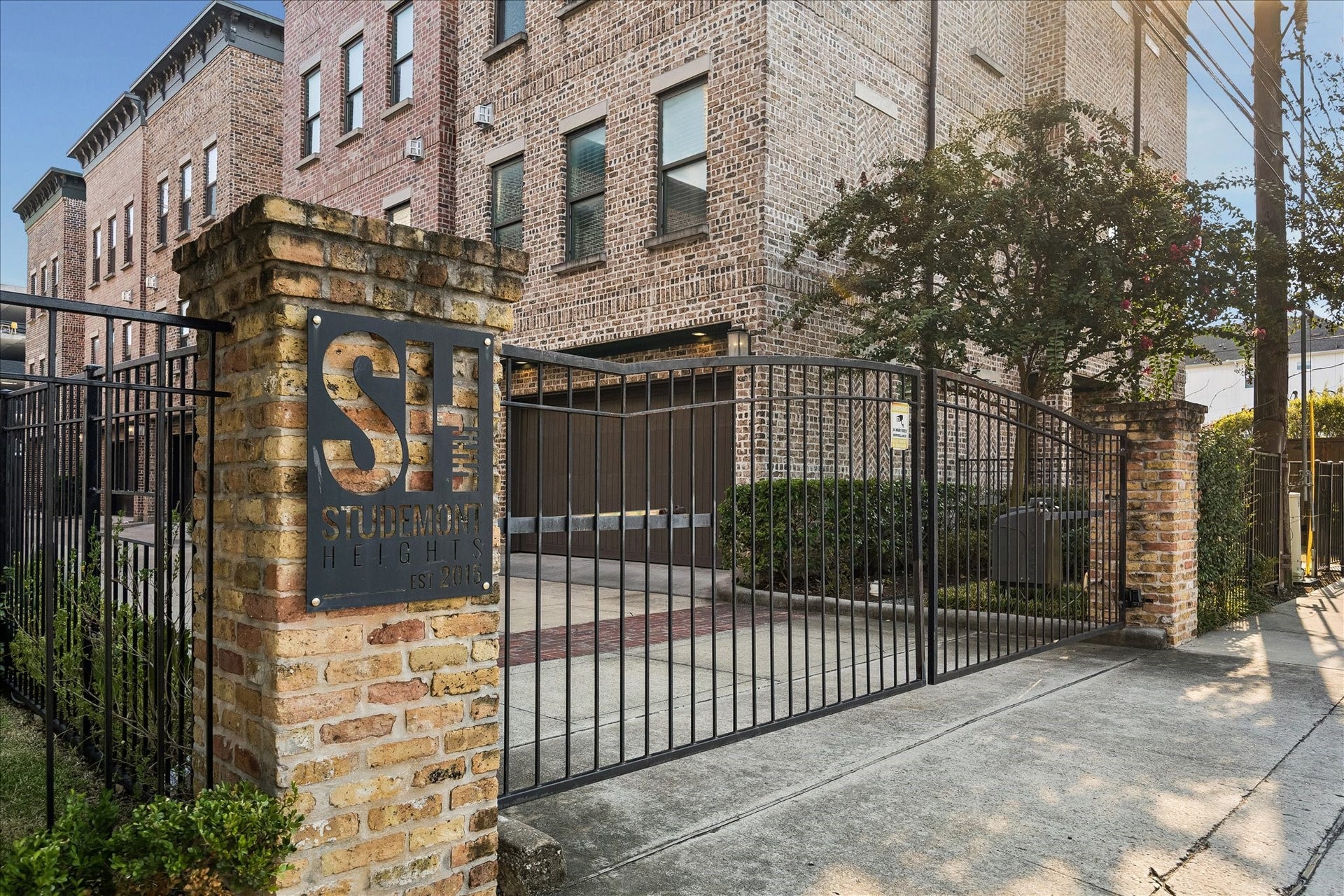 2915 Hicks Street, Houston, TX 77007 Gated entry to a charming brick townhouse community at Studemont Heights, offering security and elegance in a modern urban setting.