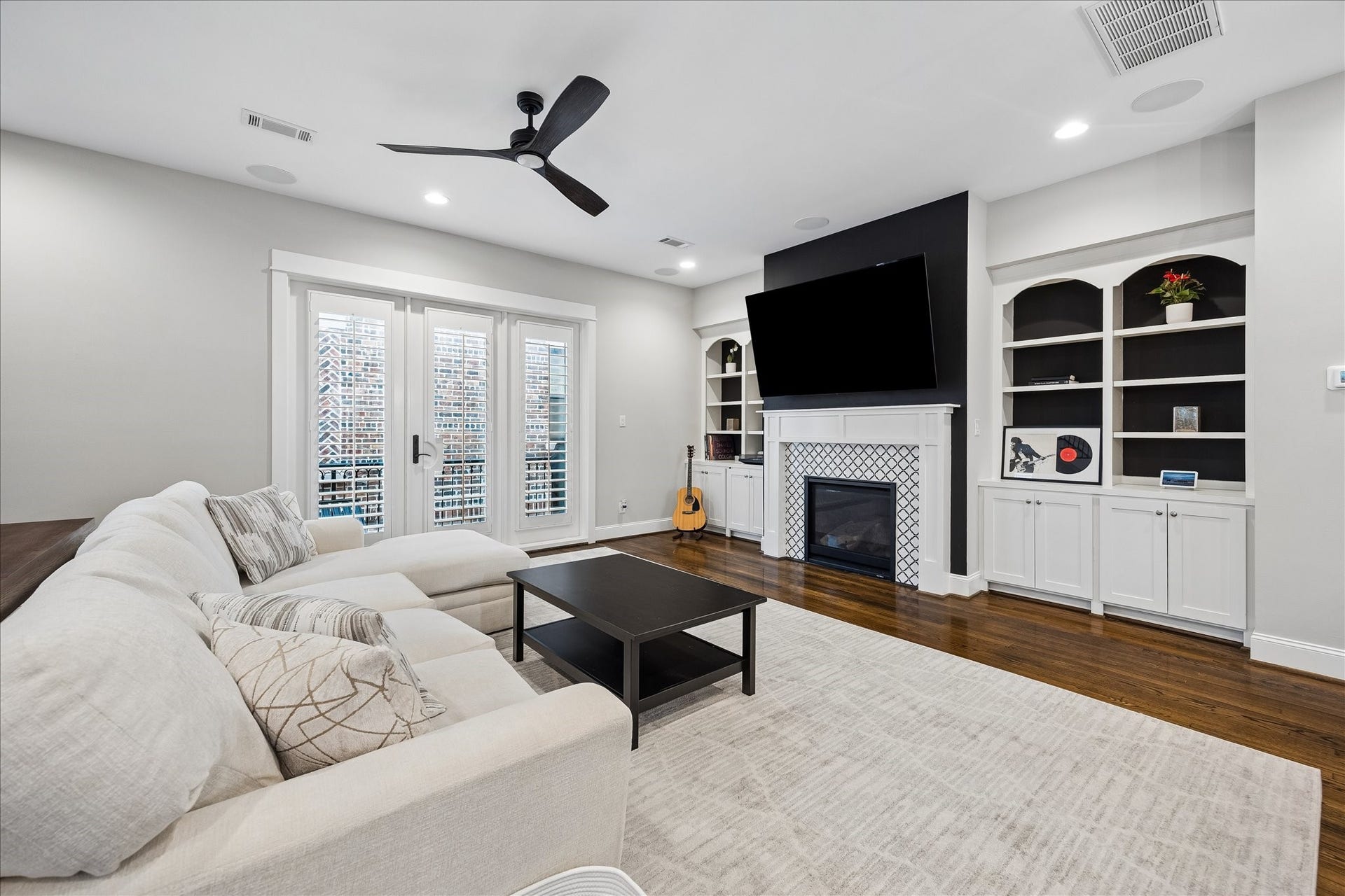2915 Hicks Street, Houston, TX 77007 Spacious living room featuring elegant built-ins, a cozy fireplace, and ample natural light through stylish French doors.