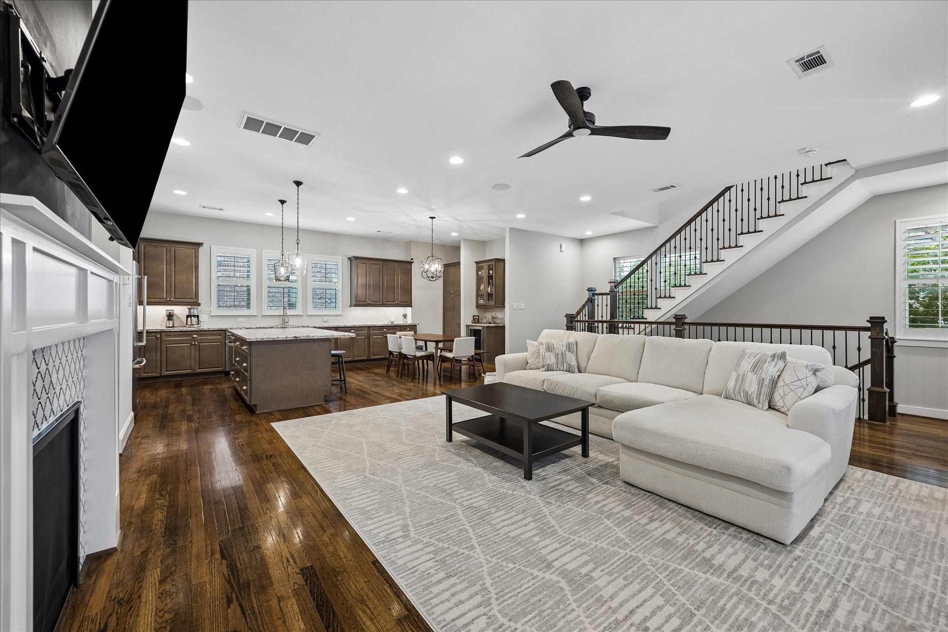 2915 Hicks Street, Houston, TX 77007 Spacious open-concept living area featuring a modern kitchen with a large island, elegant cabinetry, a cozy living room and a sleek staircase leading to the upper level.