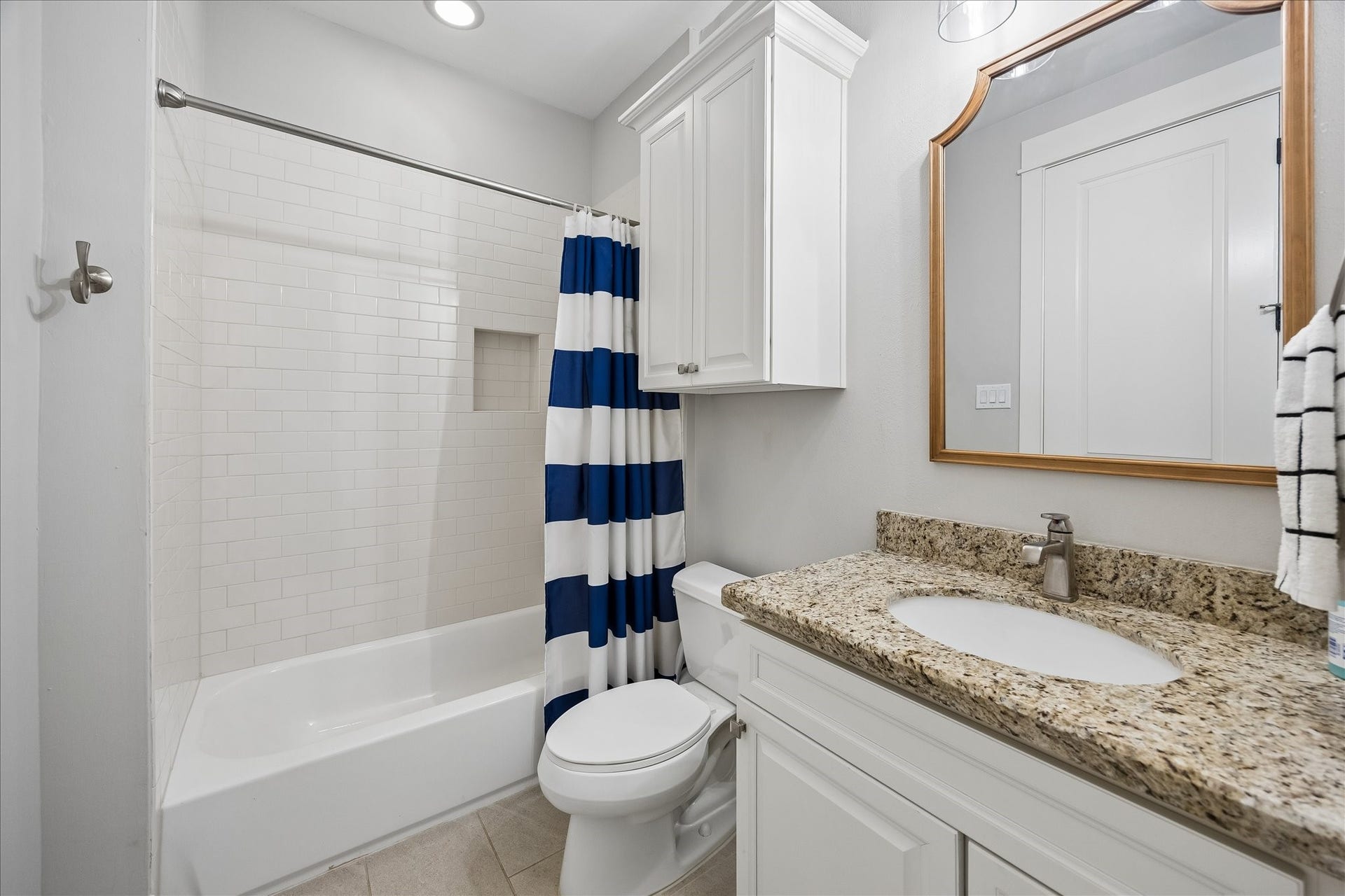 2915 Hicks Street, Houston, TX 77007 Charming bathroom featuring a granite countertop and a classic white vanity, complemented by a tiled tub shower