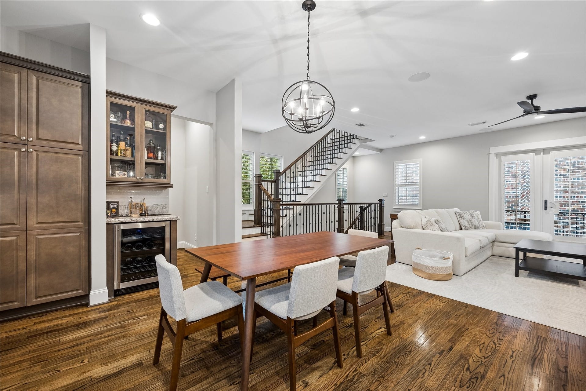 2915 Hicks Street, Houston, TX 77007 Elegant open-concept living space featuring a sleek dining area, modern lighting, and a cozy living room. The room is highlighted by a beautiful staircase, ample natural light, and a convenient built-in bar for entertaining.