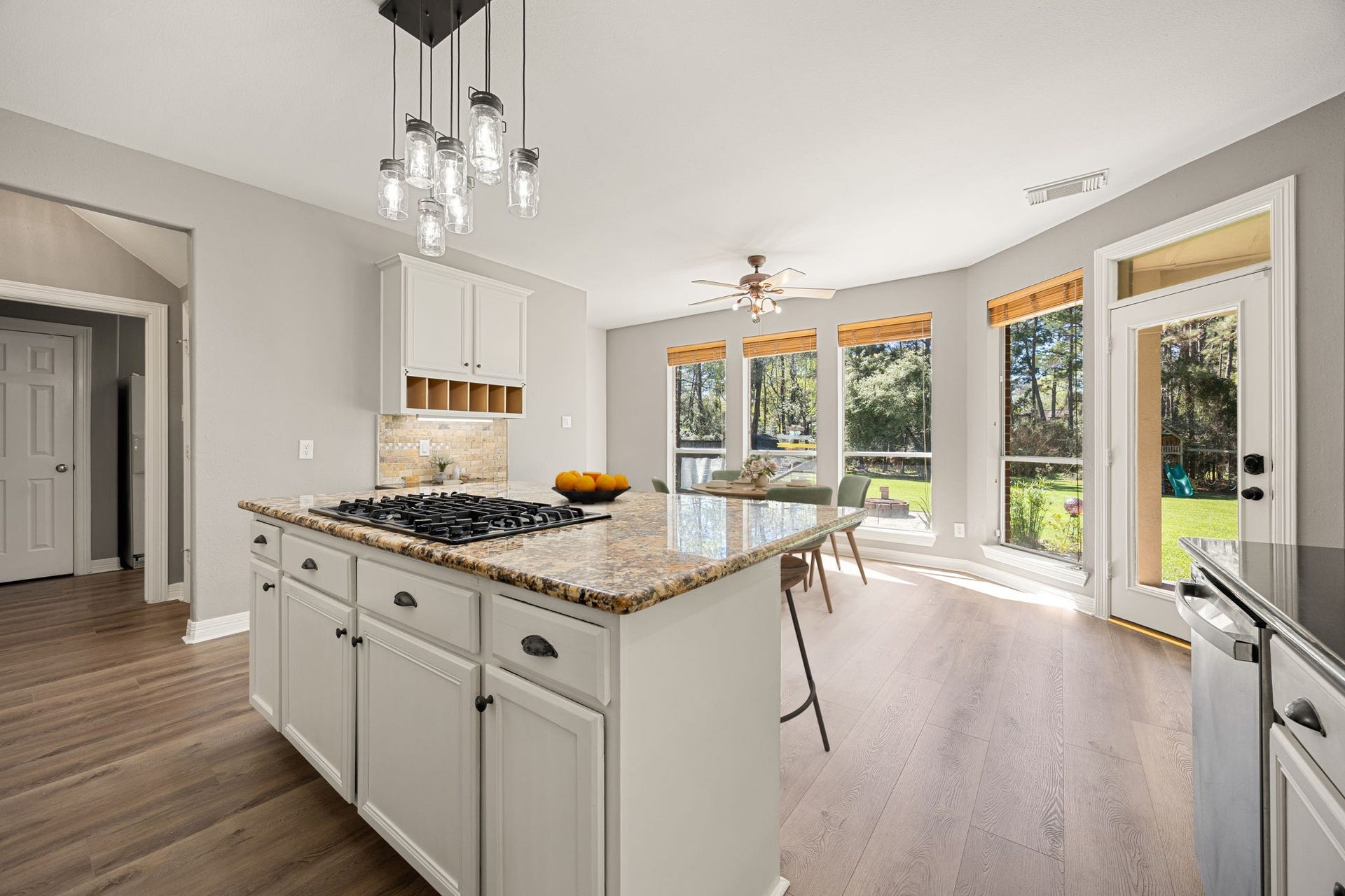 Beautiful kitchen with oversized island, granite countertops, and a sunny breakfast area with backyard views. Large windows fill the space with natural light, making this kitchen both functional and inviting. *virtually staged*