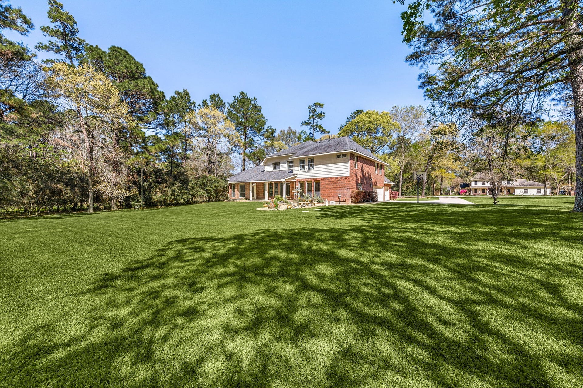 Enjoy the wide-open backyard surrounded by mature trees, providing privacy, shade, and plenty of room for outdoor activities.