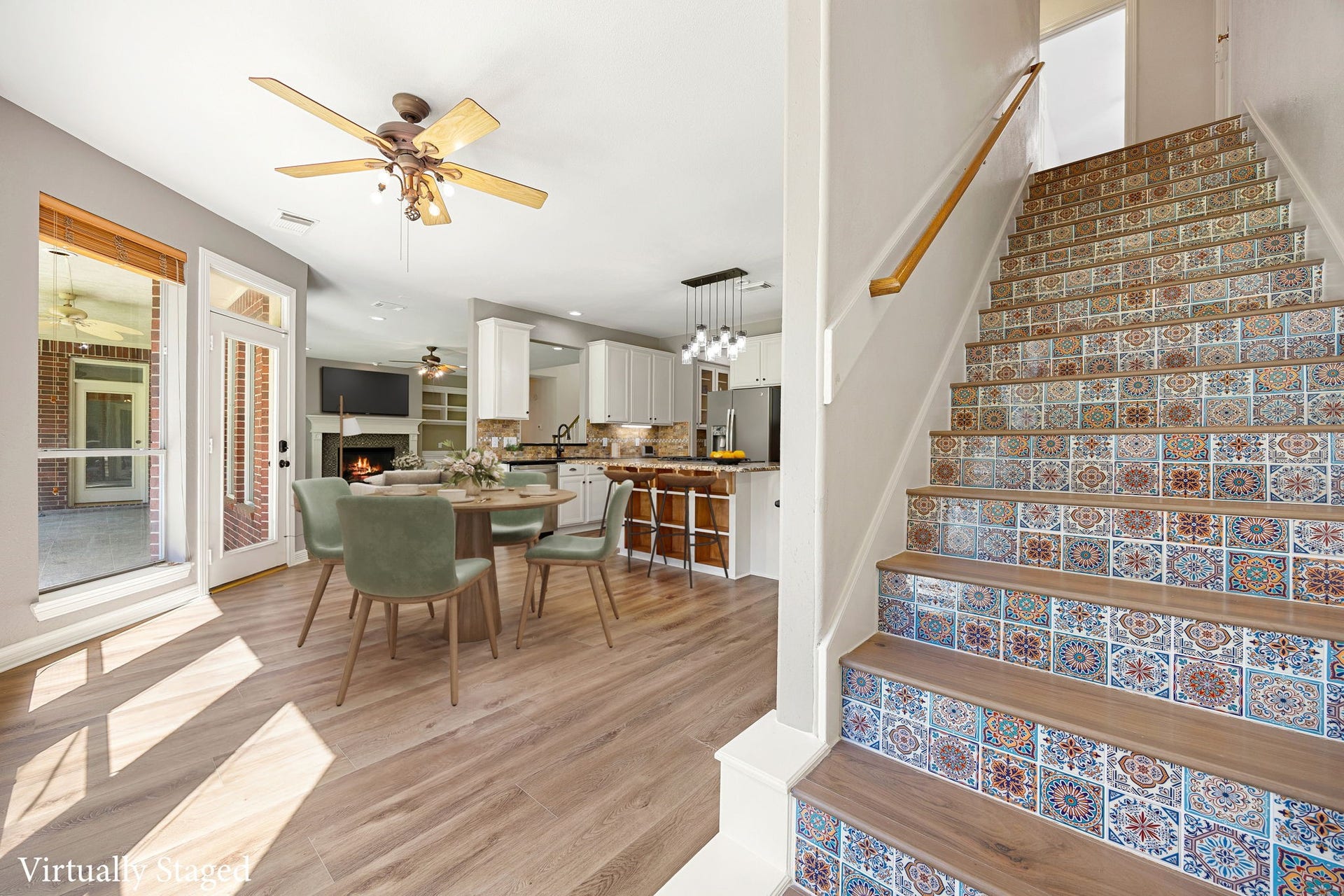 Bright open floor plan with views of the kitchen, dining, and living areas, plus a beautifully detailed staircase that adds charm and personality to the space. *virtually staged*