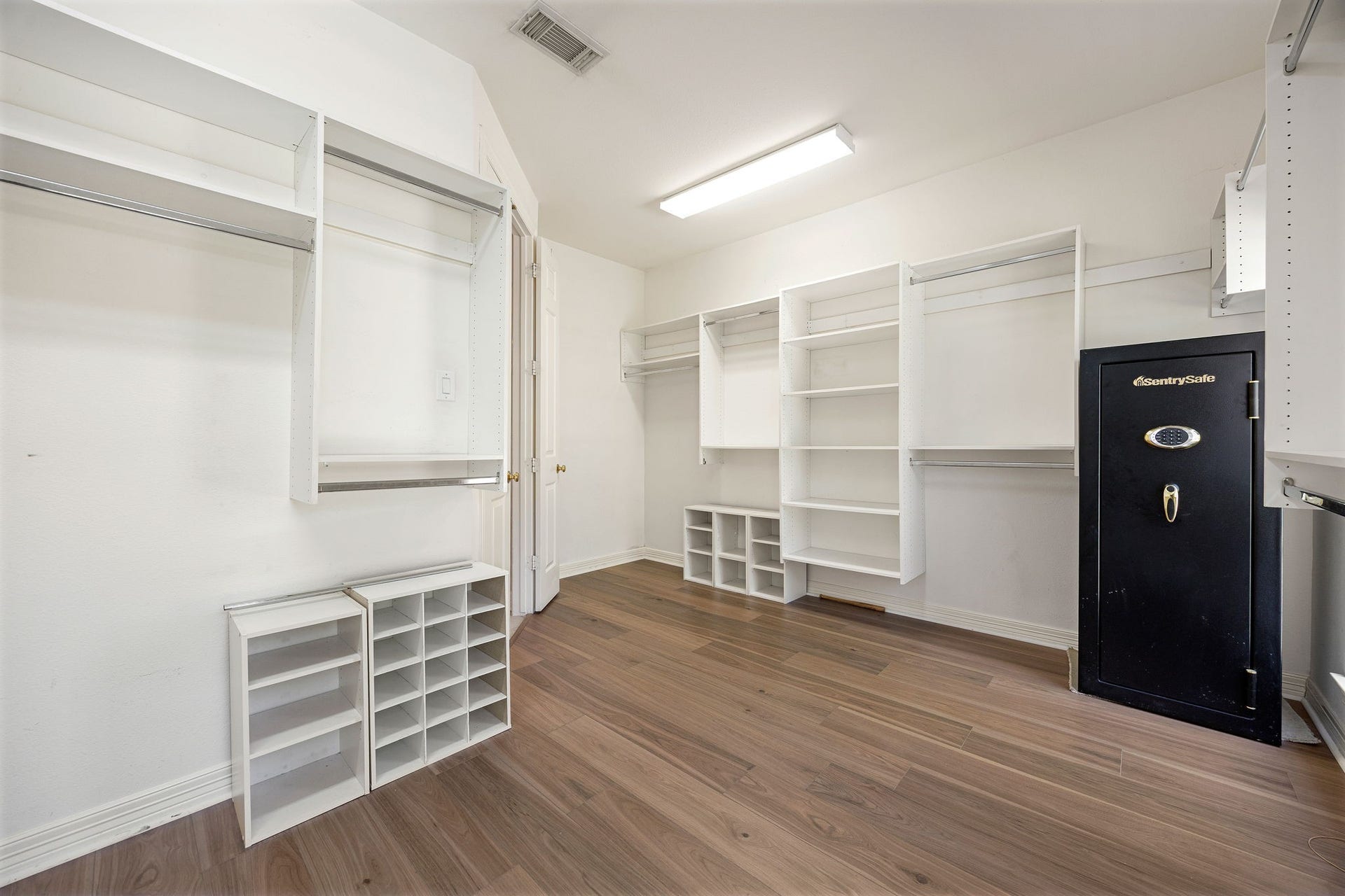 Spacious walk-in closet featuring built-in shelves, multiple hanging areas, and plenty of room for storage and organization.