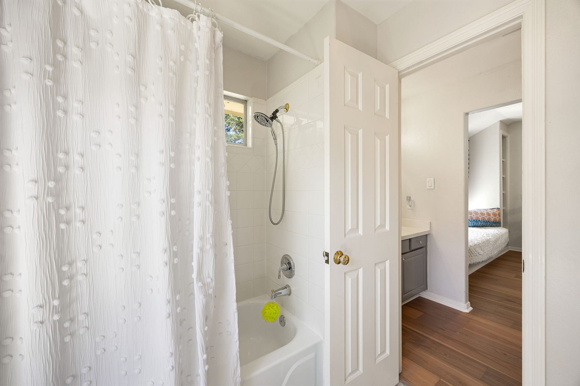 Secondary bathroom with tub and shower combination, offering comfort and functionality for family or guests.