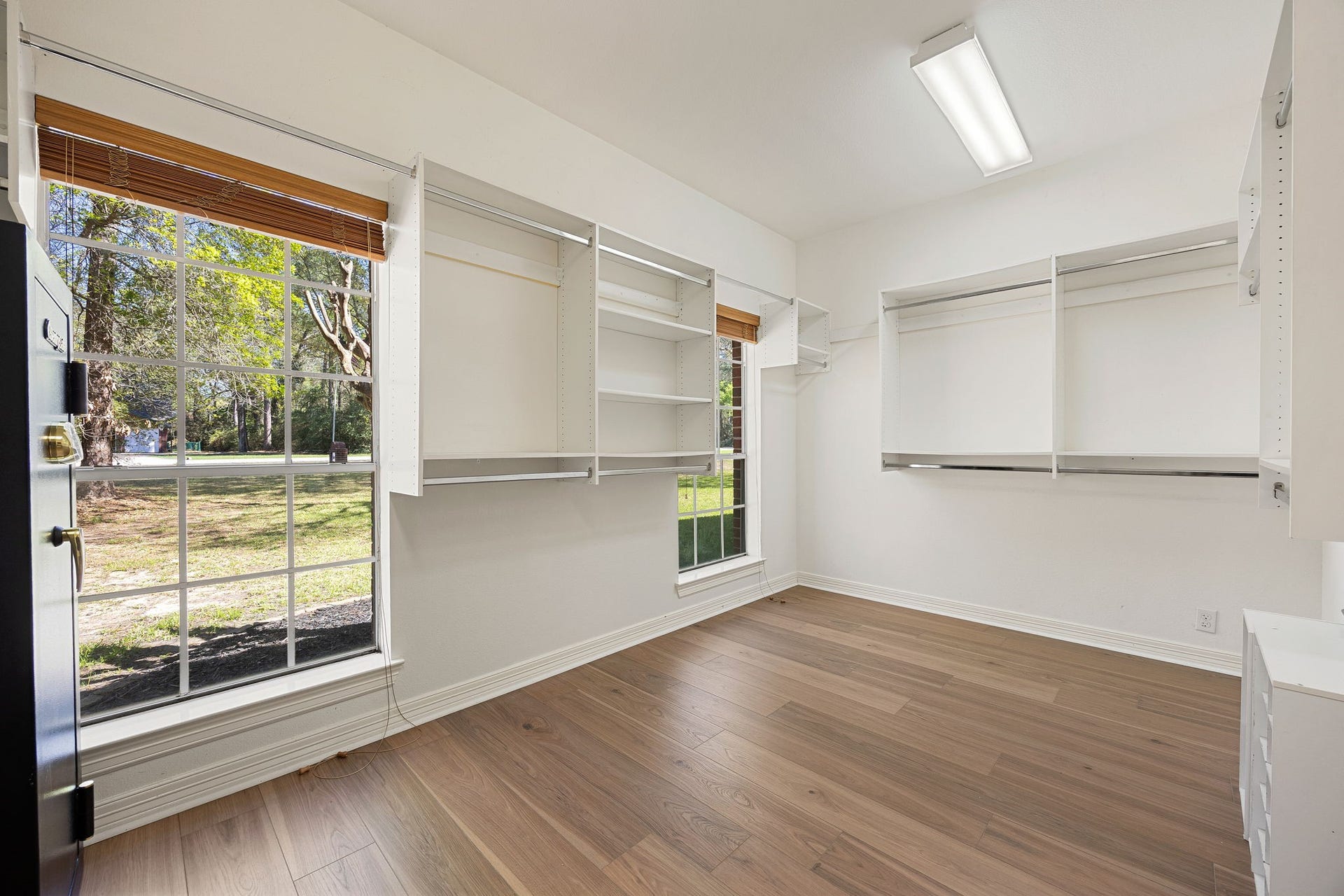 Huge walk-in closet with built-in shelves, large windows, and plenty of space to keep everything organized.