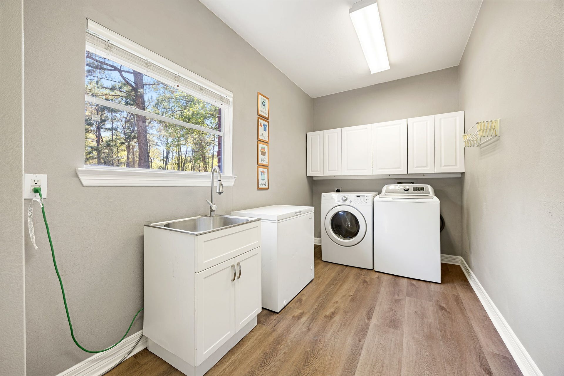 Bright and spacious laundry room with sink, cabinets, and plenty of space for storage and organization.