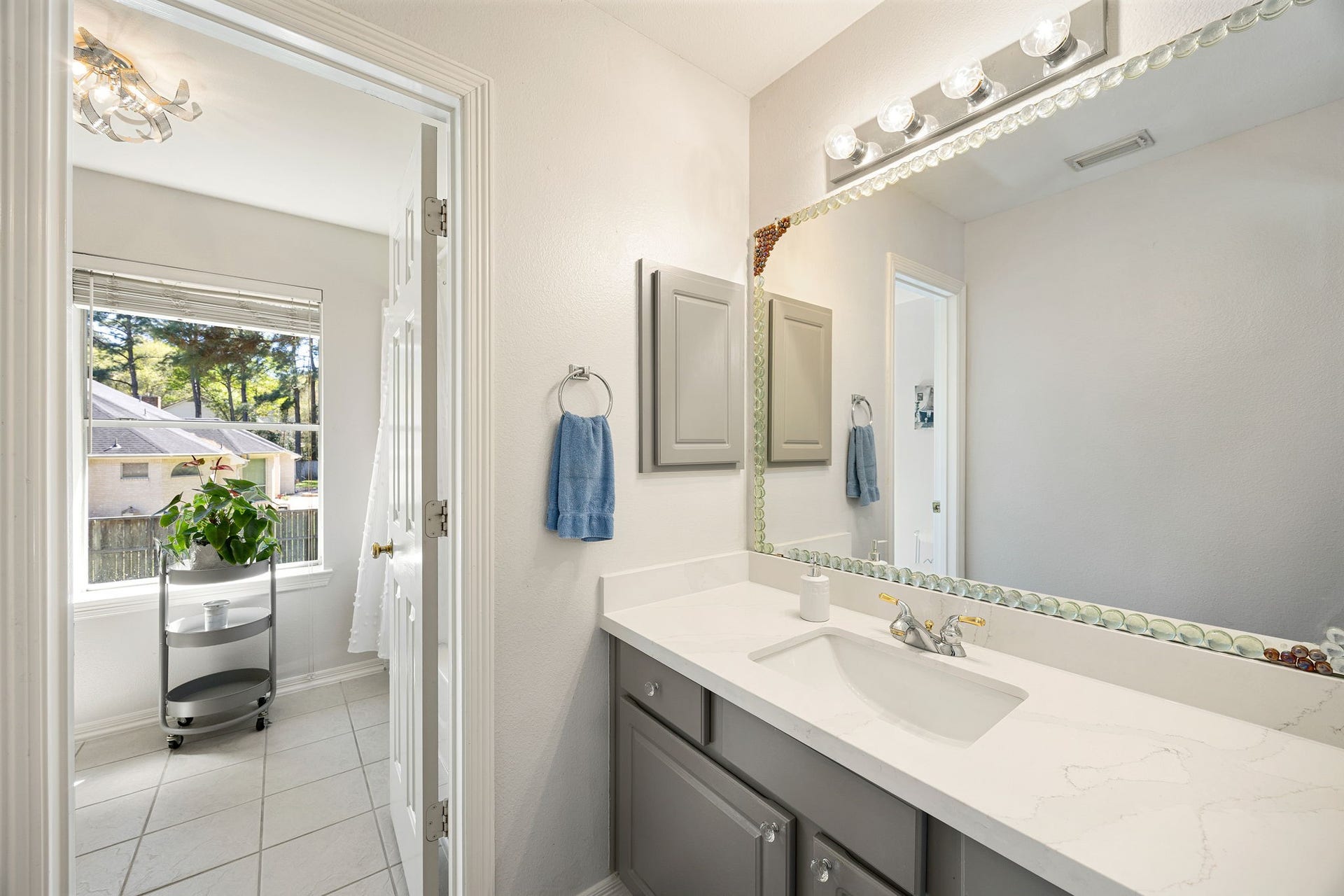 Clean and functional bathroom with vanity and mirror, ideal for family or guests.