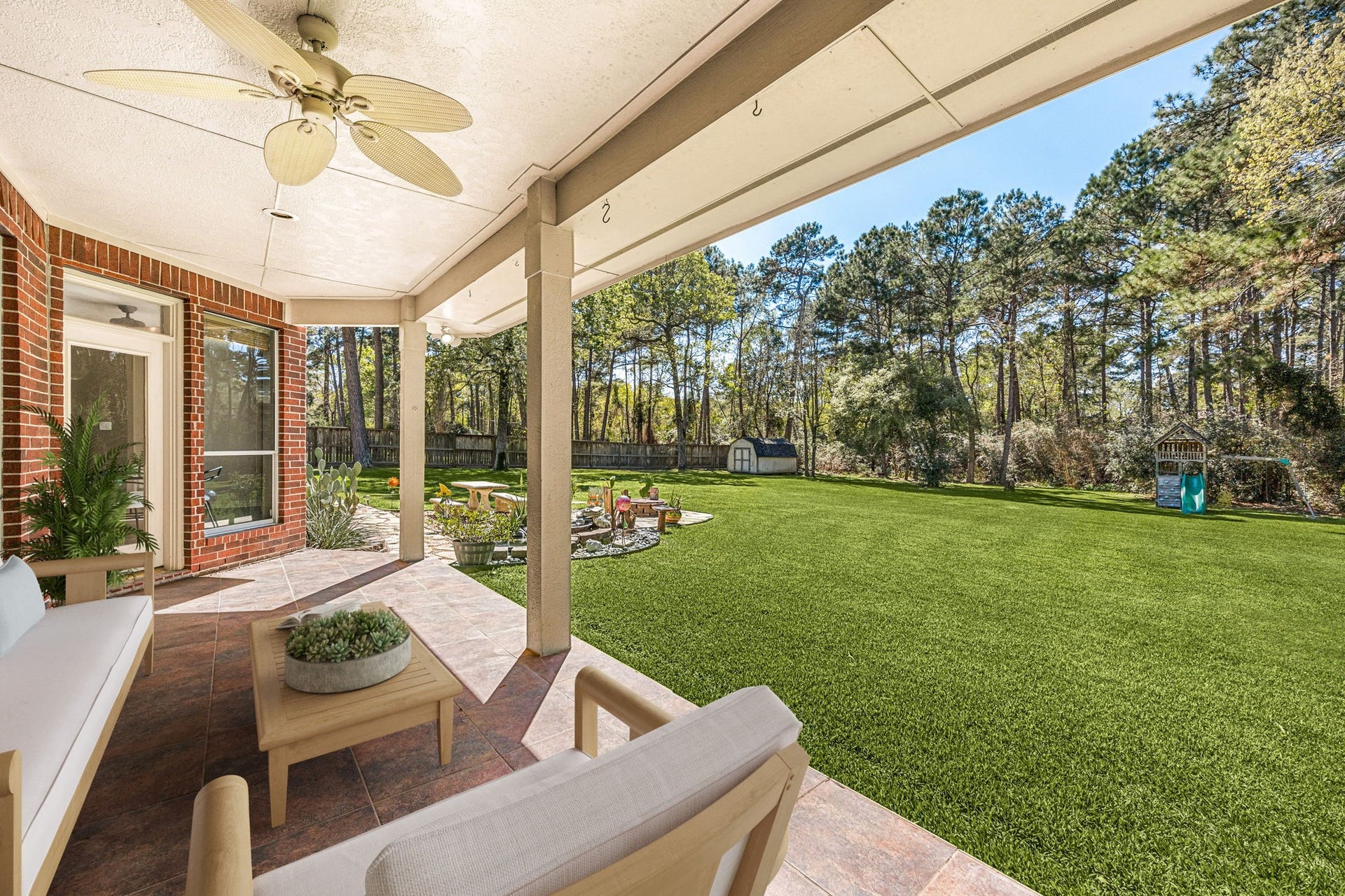 Enjoy the spacious covered patio overlooking a large backyard with mature trees, perfect for relaxing, entertaining, or outdoor activities. *virtually staged*