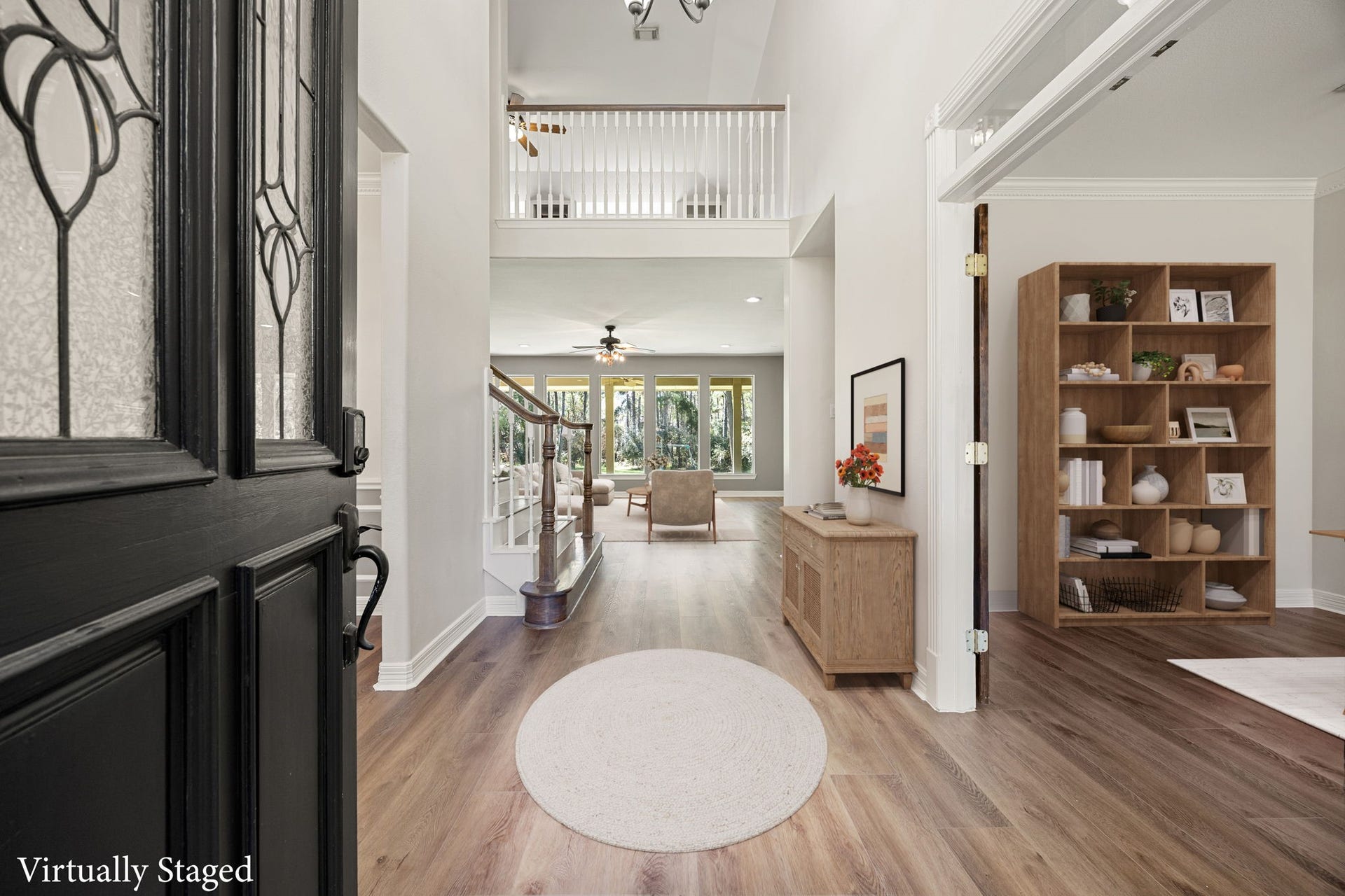 Step inside to a grand entry featuring soaring ceilings, beautiful flooring, and an open layout that immediately creates a bright and welcoming atmosphere. The elegant staircase and large windows allow natural light to fill the space, giving the home a spacious and airy feel. *virtually staged*