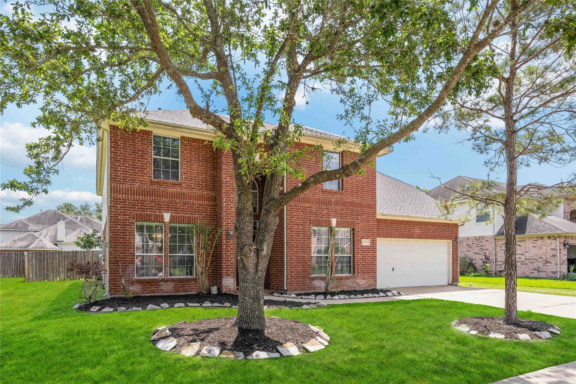 5727 Candlecreek Drive, Richmond, TX 77469 This angle highlights the mature shade tree and landscaped front yard. It creates a welcoming setting before you ever step inside.