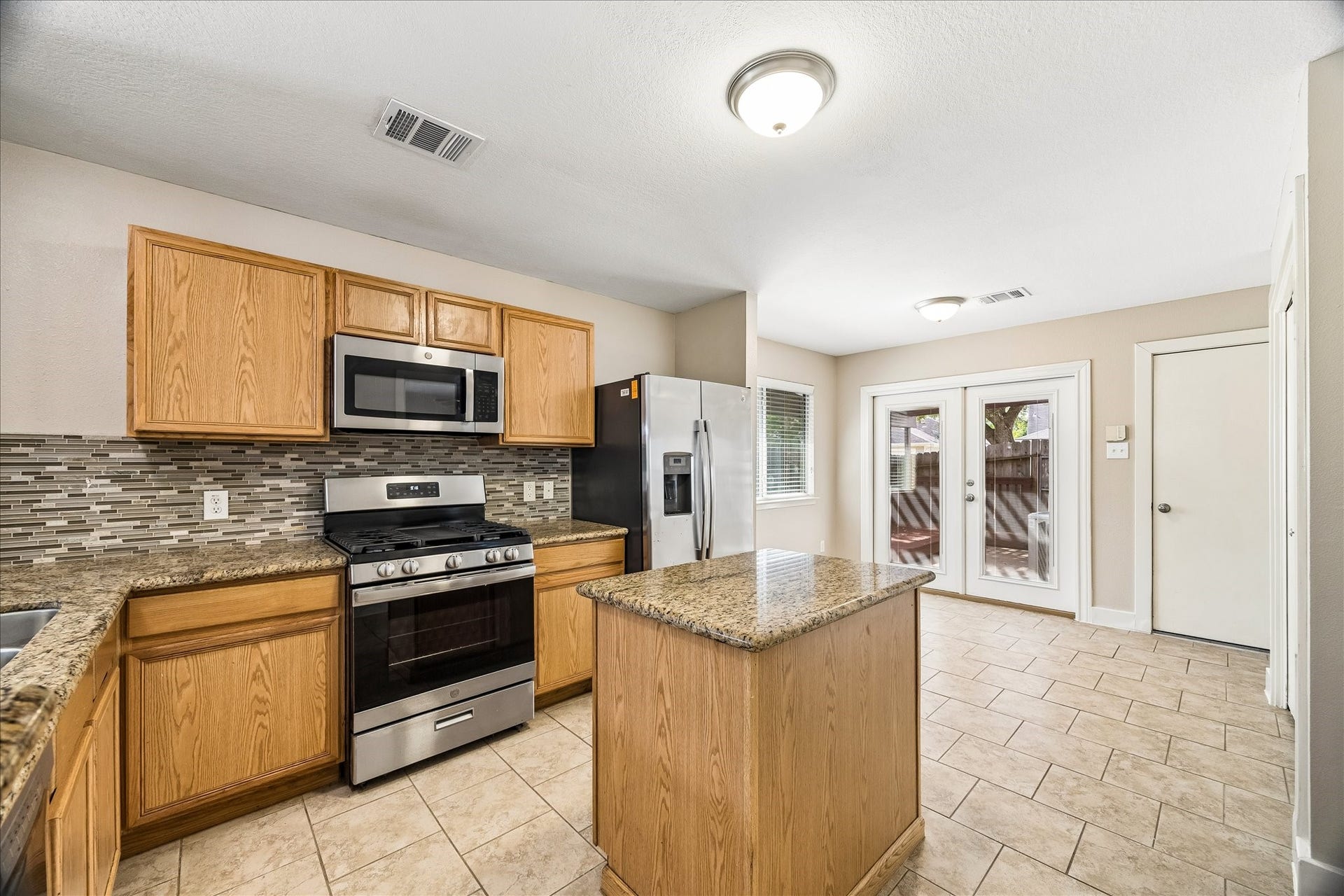10819 Cobblecreek Way, Missouri City, TX 77459 French doors lead from the eat-in kitchen to the pergola covered patio, making it easy to open the doors, let the fresh air in, and expand your everyday living outdoors.
