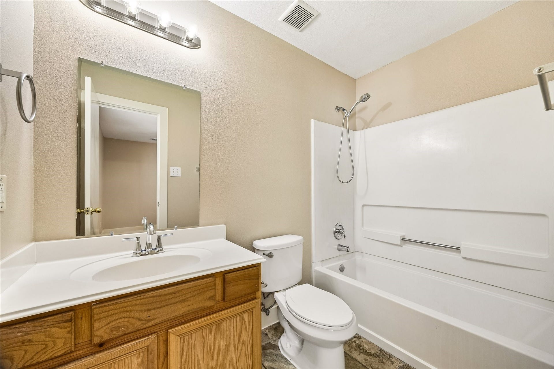 10819 Cobblecreek Way, Missouri City, TX 77459 This ensuite bathroom offers a clean, simple design with a single sink vanity, full mirror, vanity lights, and a convenient tub and shower combo for everyday ease.