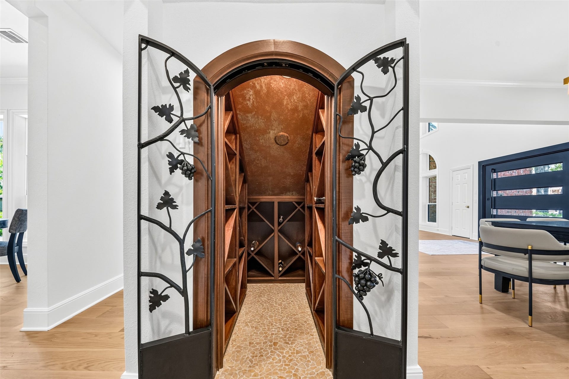 46 Pebble Cove Drive, The Woodlands, TX 77381 Elegant wine cellar with custom wrought iron doors and rich wood shelving, perfect for showcasing your collection.