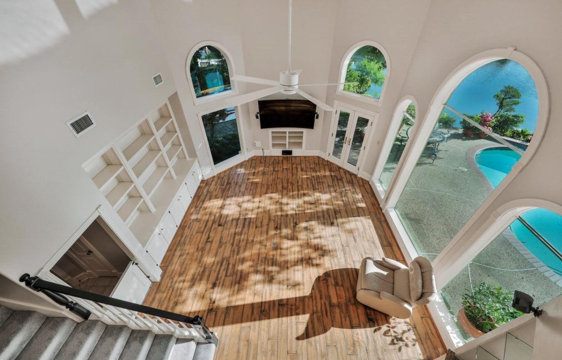 35 W Isle Place, The Woodlands, TX 77381 Stunning two-story living room with dramatic windows, soaring ceilings, and elegant architectural details.