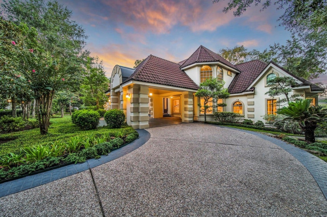 35 W Isle Place, The Woodlands, TX 77381 Expansive circular driveway leading to the stately residence surrounded by mature landscaping.