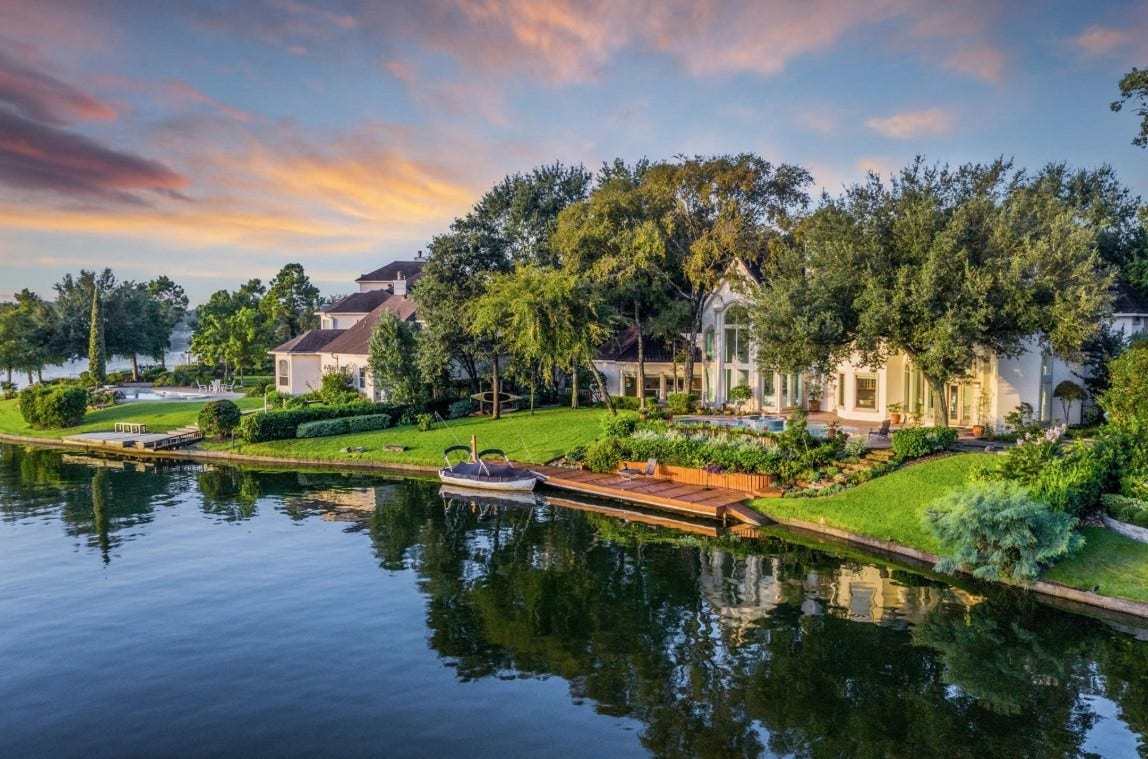 35 W Isle Place, The Woodlands, TX 77381 Scenic waterfront backyard with lush greenery, private dock, and tranquil lake views.