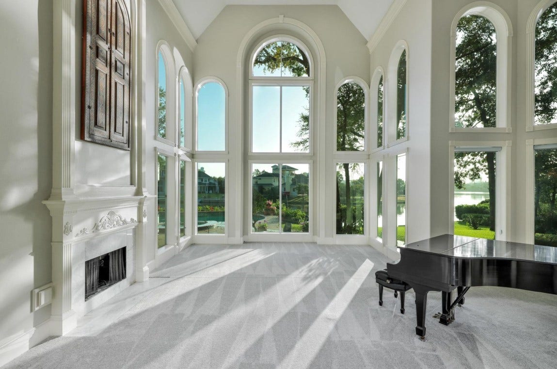 35 W Isle Place, The Woodlands, TX 77381 Elegant formal entry with dramatic arched windows, marble flooring, and luxurious finishes.