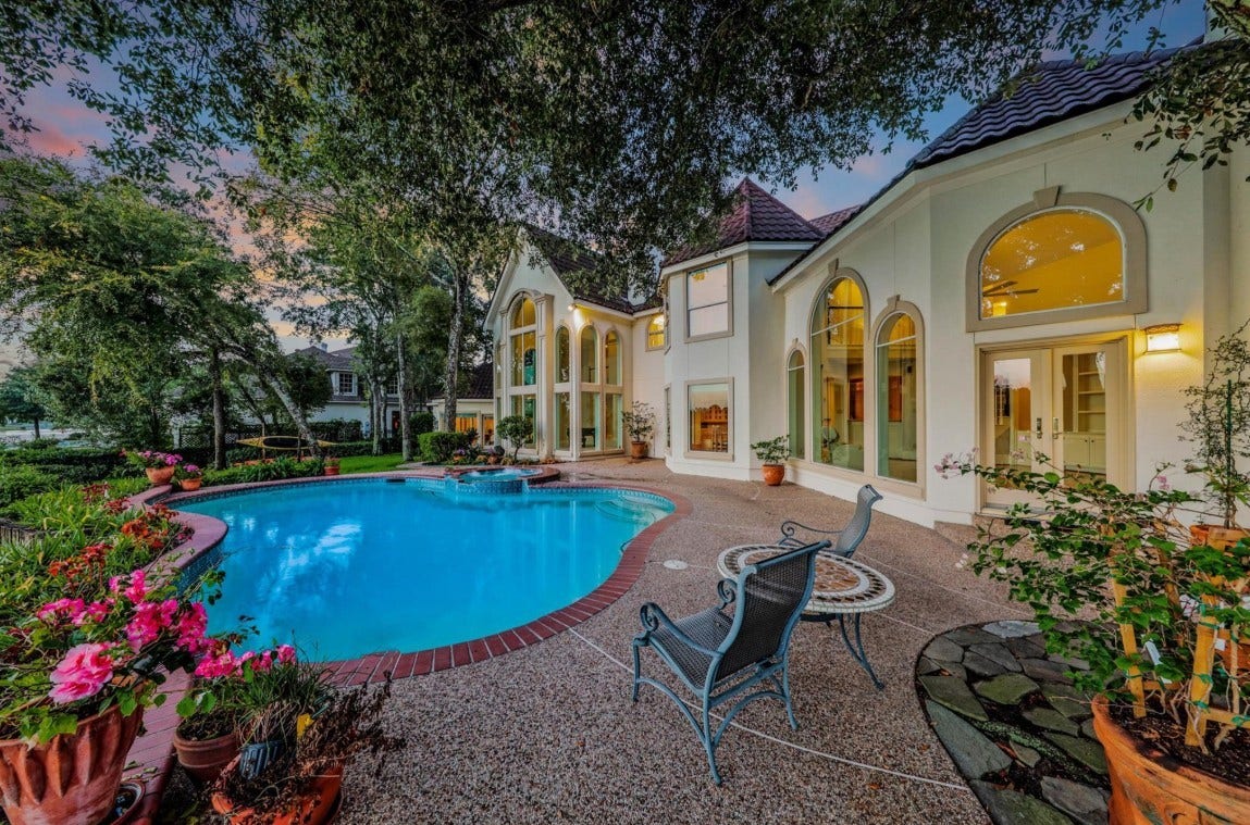 35 W Isle Place, The Woodlands, TX 77381 Private backyard oasis with a pool, spacious patio, and lush landscapingperfect for entertaining.