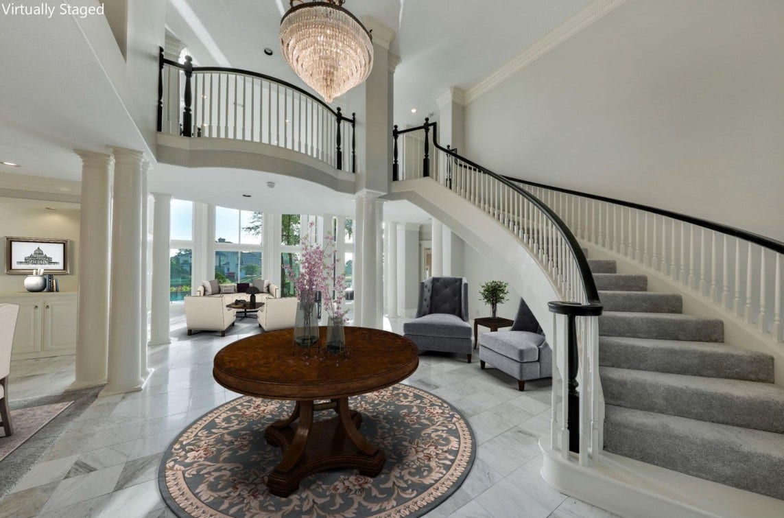 35 W Isle Place, The Woodlands, TX 77381 Grand foyer featuring a sweeping staircase, soaring ceilings, and abundant natural light.