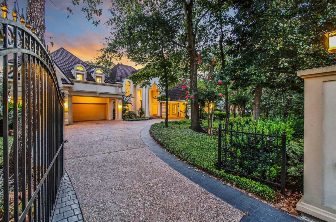 35 W Isle Place, The Woodlands, TX 77381 Gated driveway leading to the impressive estate with mature landscaping and privacy.