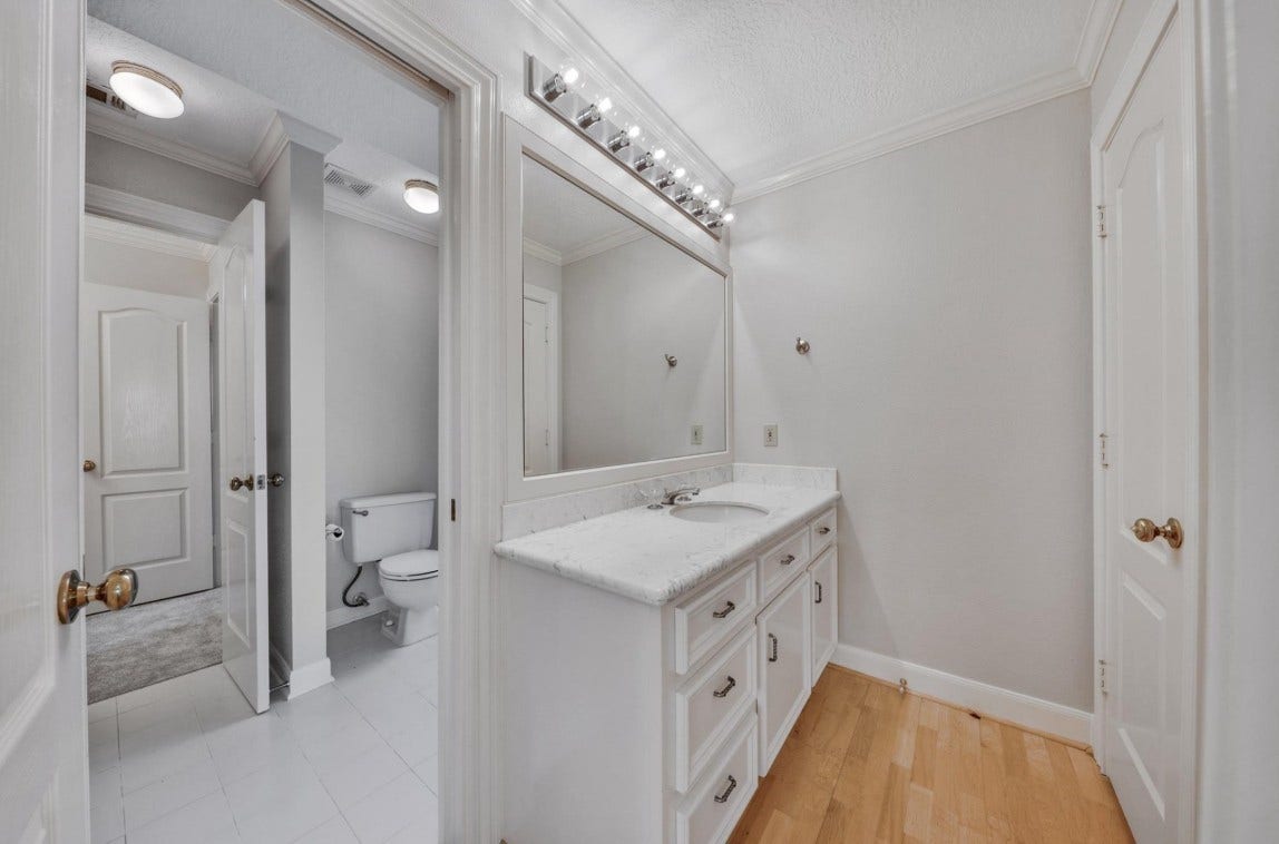 35 W Isle Place, The Woodlands, TX 77381 Elegantbathroom featuring a oversized mirror, modern fixtures, and ample storage.