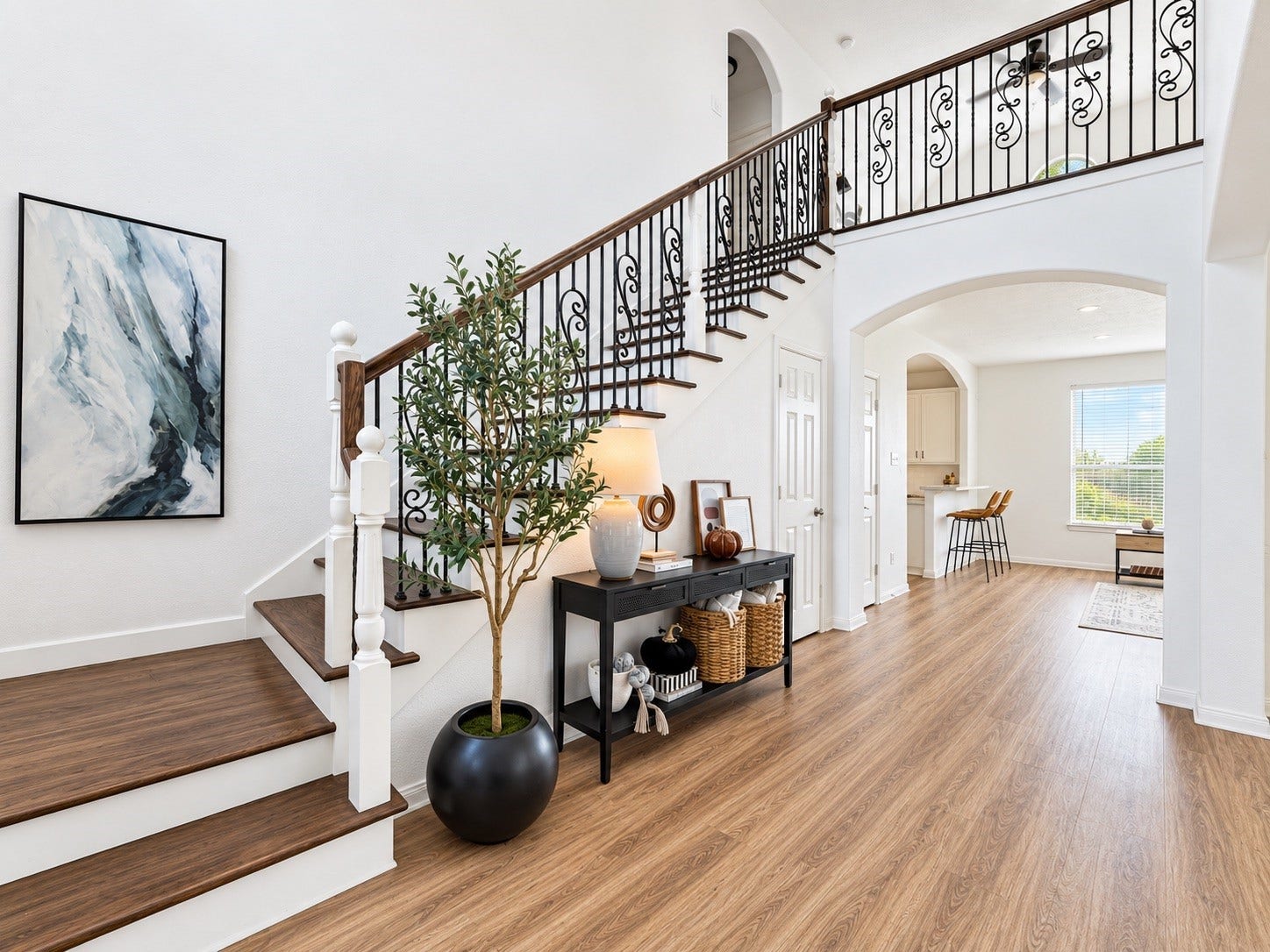 21418 Avalon Queen Drive, Spring, TX 77379 Grand entryway featuring elegant hardwood floors and a sweeping staircase with intricate wrought-iron detailing, setting a welcoming tone for the home.