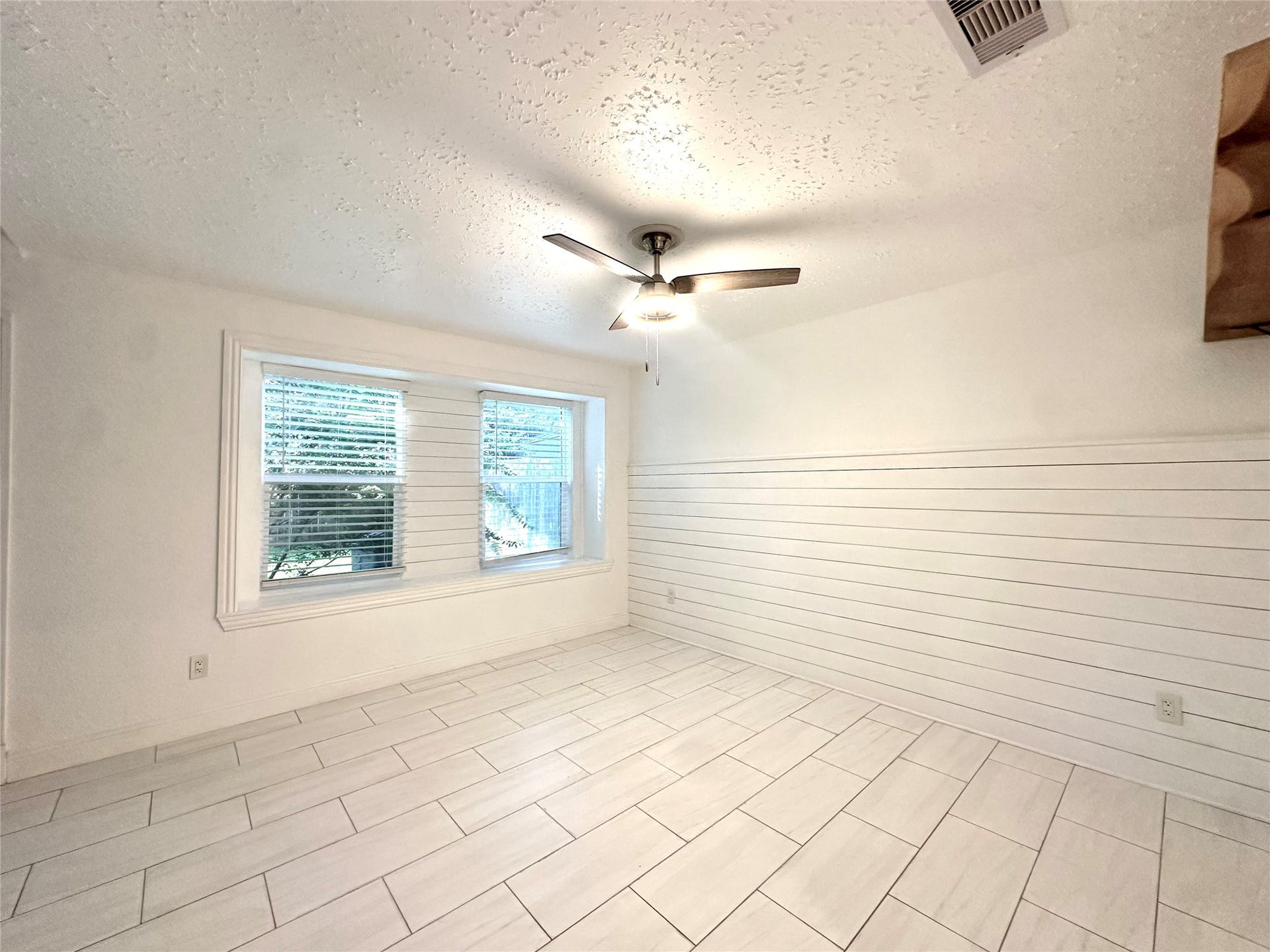 3411 Cannon Ridge Drive, Richmond, TX 77406 Modern kitchen featuring sleek stainless steel appliances, elegant white cabinetry, and a stylish marble-look countertop, complemented by a chic ceiling fan and recessed lighting.