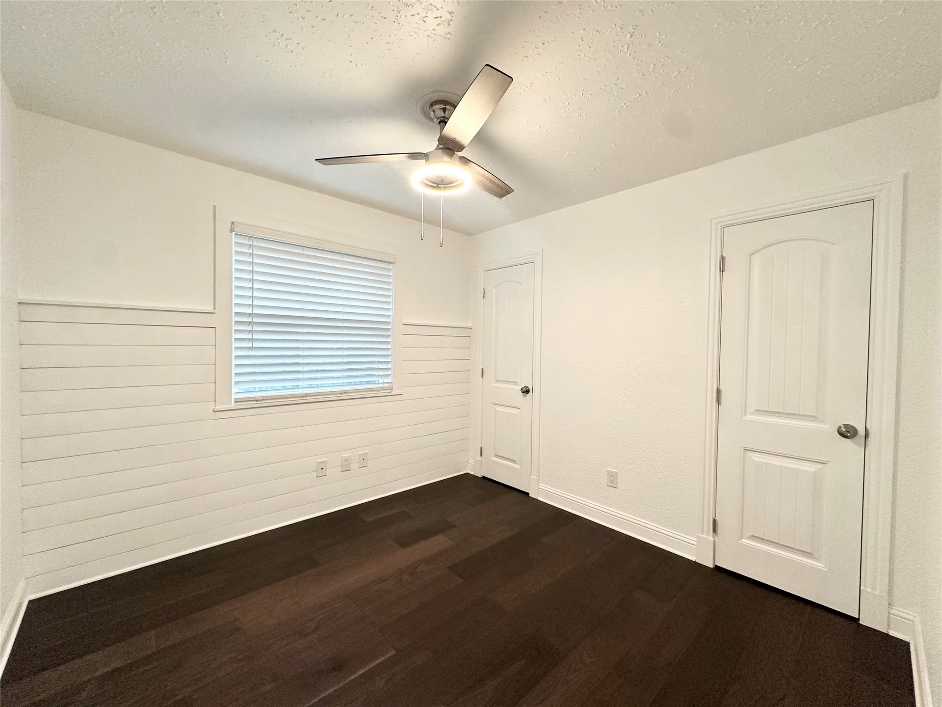 3411 Cannon Ridge Drive, Richmond, TX 77406 Charming room with fresh paint and elegant wood flooring, featuring a modern ceiling fan and ample natural light.