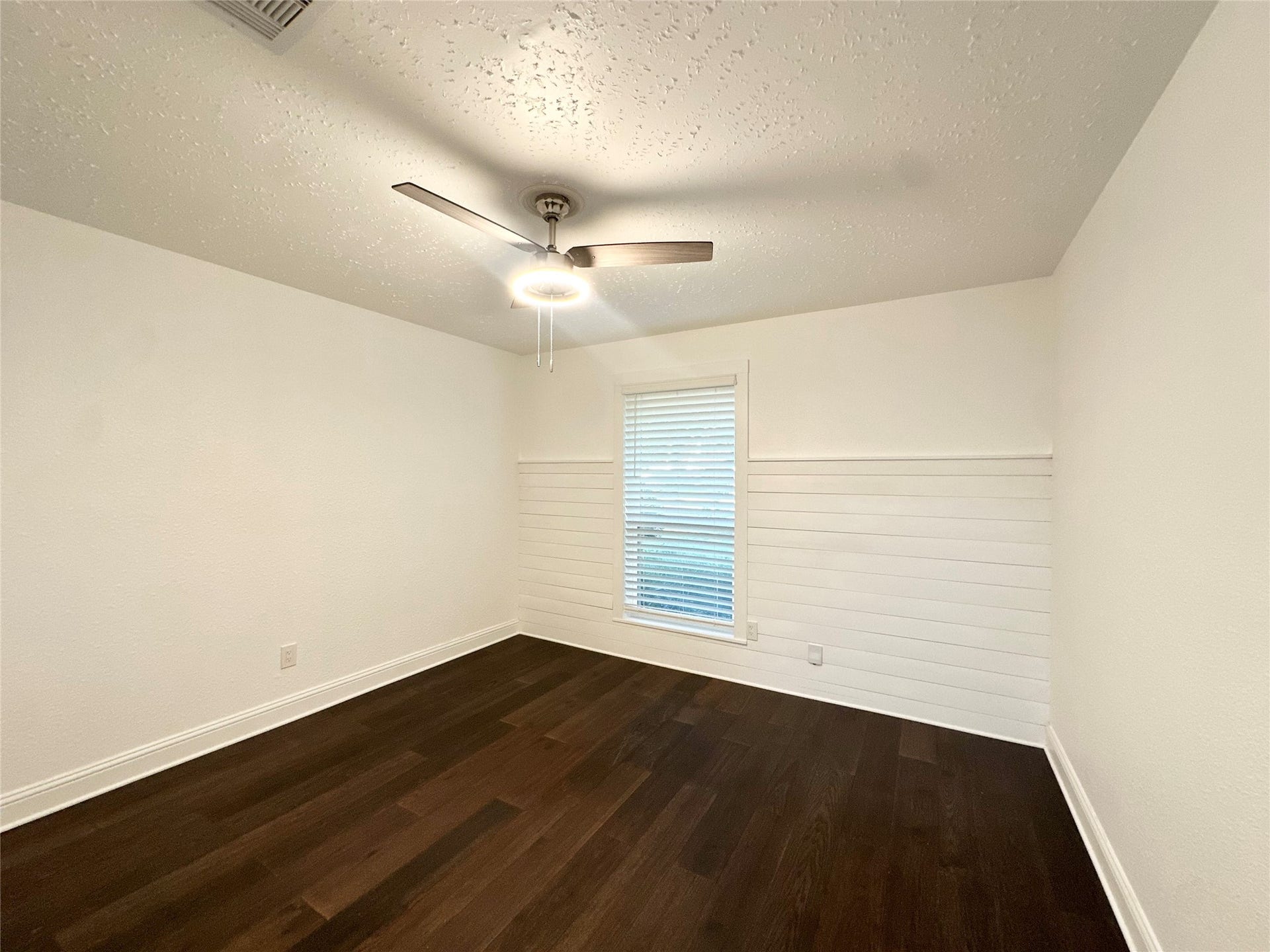 3411 Cannon Ridge Drive, Richmond, TX 77406 Charming bedroom with rich wood floors, a modern ceiling fan, and a large window offering natural light.