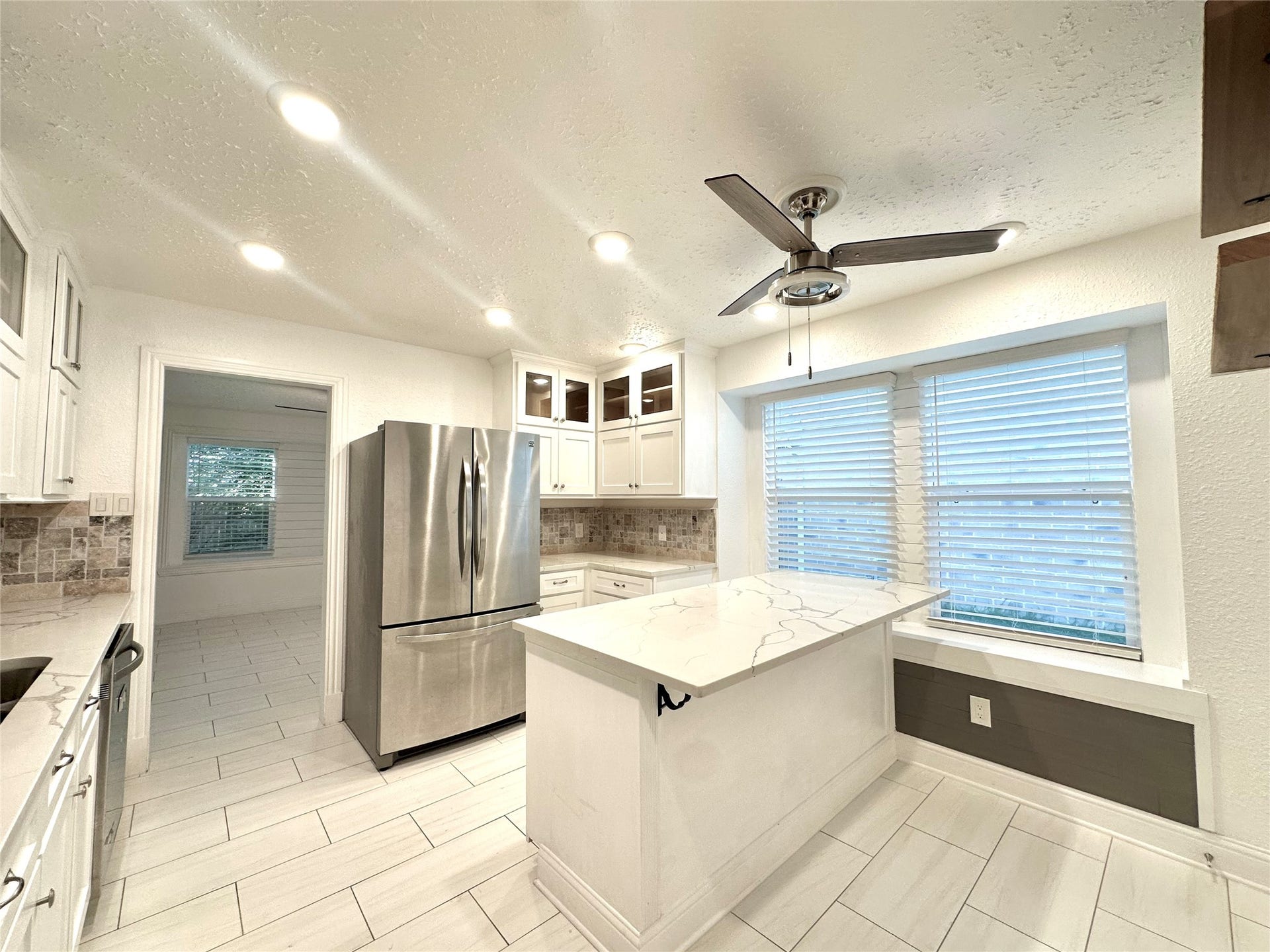 3411 Cannon Ridge Drive, Richmond, TX 77406 Spacious room with elegant dark wood flooring and soft blue walls, featuring a modern ceiling fan and ample natural light.