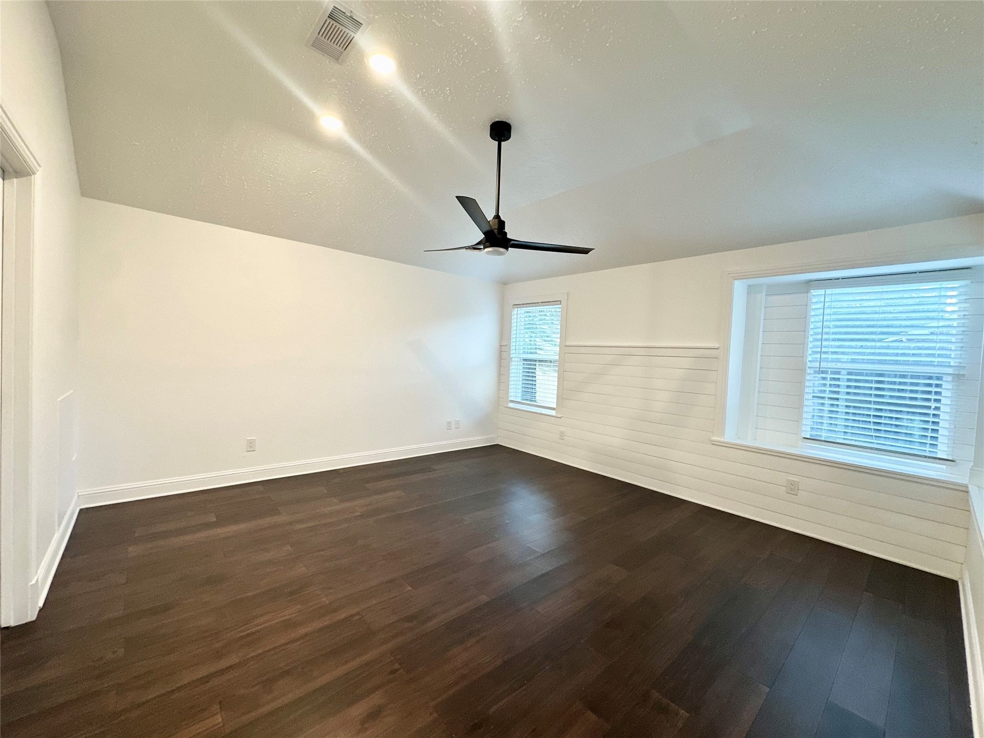 3411 Cannon Ridge Drive, Richmond, TX 77406 A bright, freshly painted room with sleek hardwood floors and modern ceiling fan, perfect for a cozy retreat.