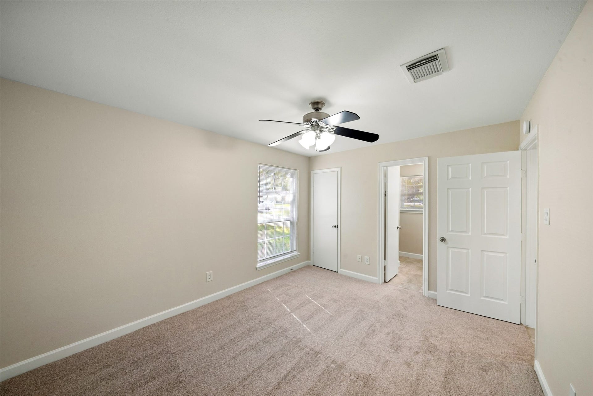3402 Dovie Drive, Spring, TX 77380 This spacious primary bedroom offers a bright, comfortable feel with brand-new carpet throughout the bedroom and closet. The windows feature new mini blinds and allow an ample amount of natural light to fill the room, creating a warm and inviting atmosphere. Neutral finishes, a ceiling fan, and convenient access to the primary bathroom complete the space.
